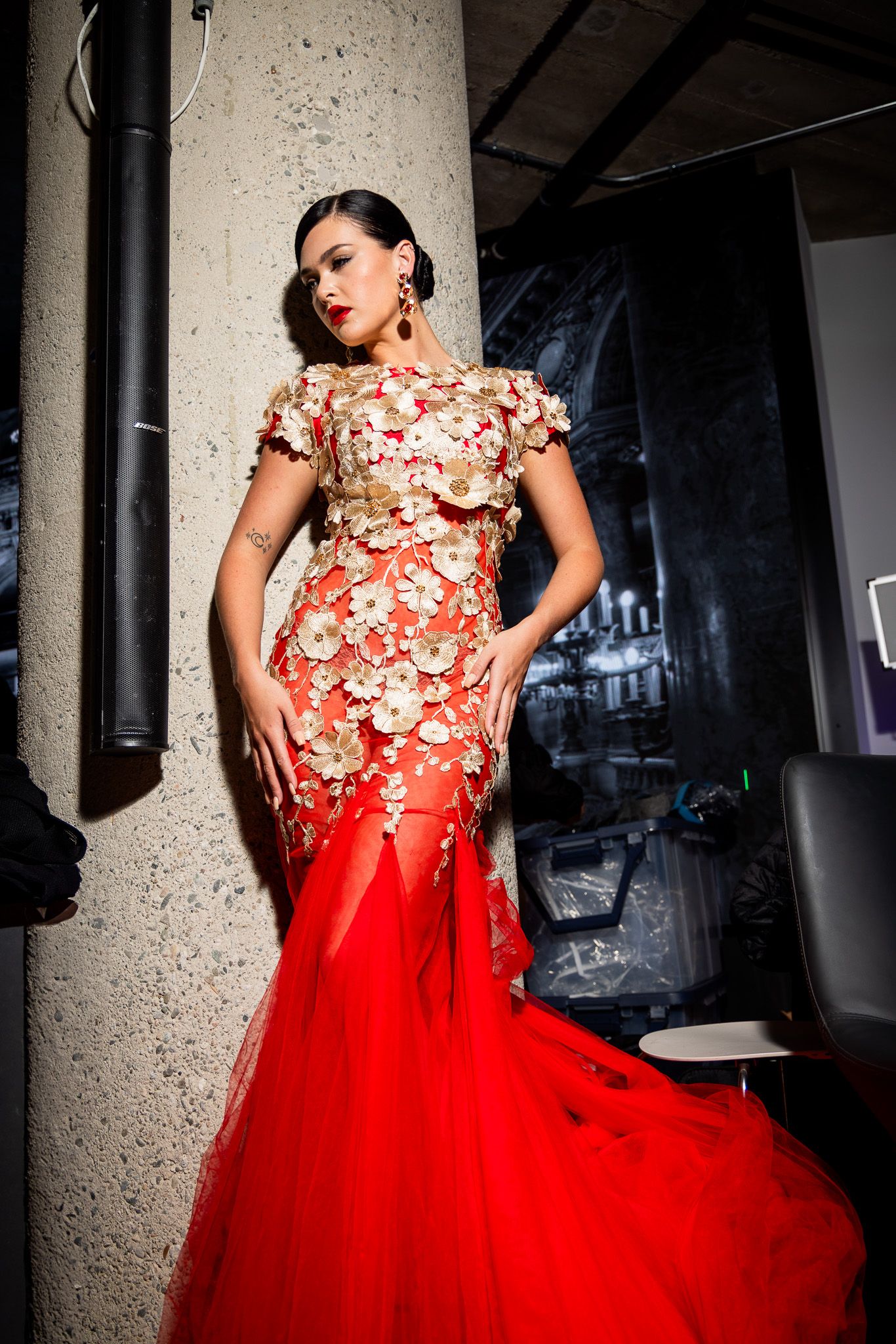 A stunning red tulle gown with floral embellishments is captured in a dramatic photoshoot sequence.