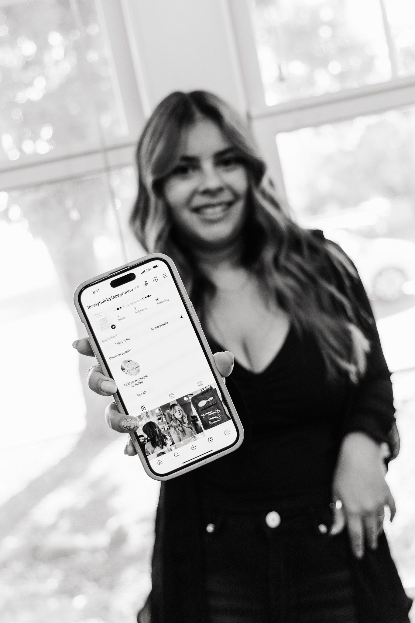 Black and white collage of someone in dark clothing holding smartphones displaying social media content.
