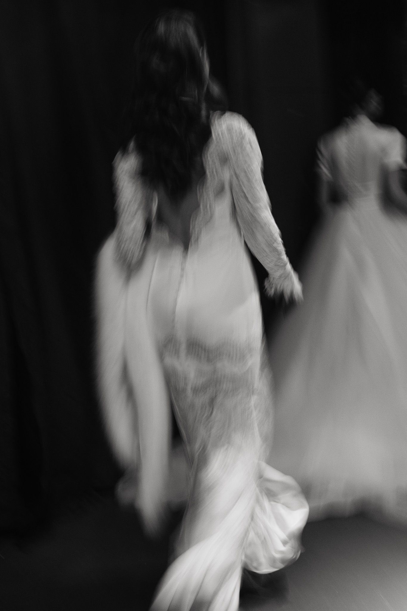 A blurred motion sequence of a person in white dress dancing, creating an ethereal ghostlike effect in black and white.