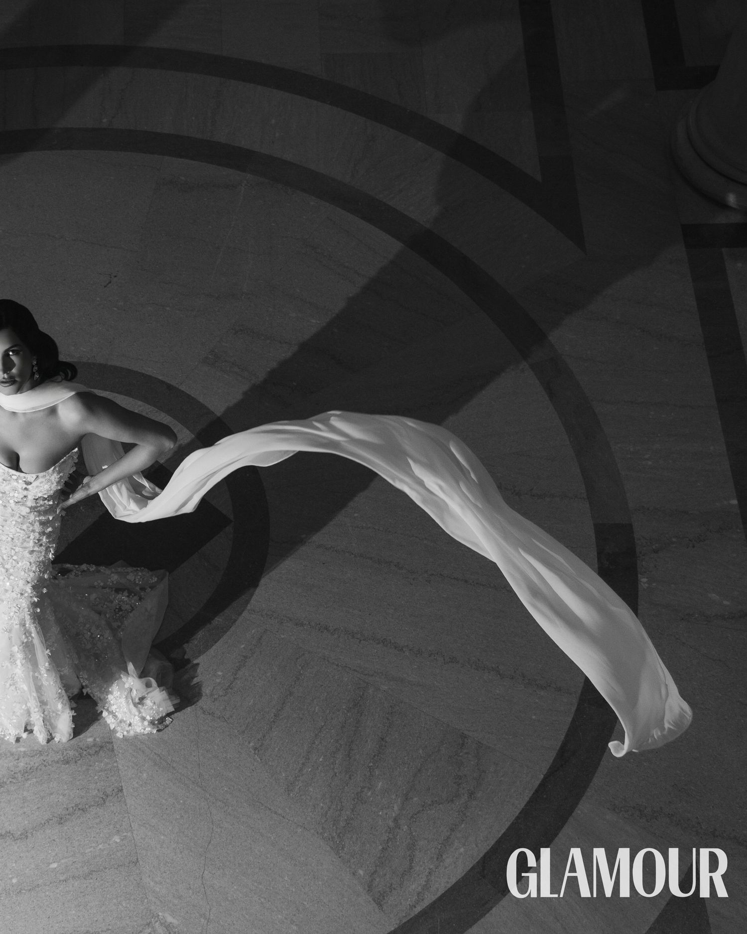 A dramatic black and white fashion editorial spread featuring flowing white fabric against a dark background.