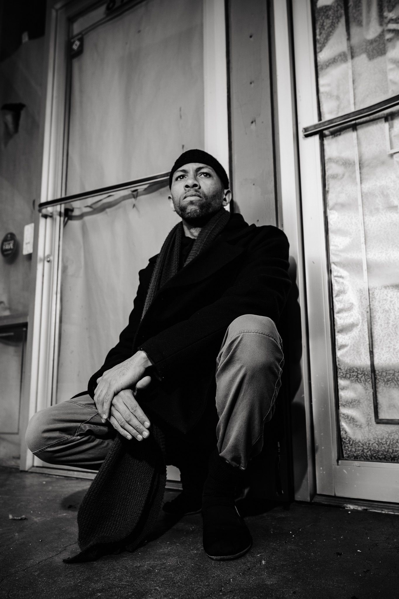 Black and white photo sequence showing someone seated on floor against wall taken from different angles.