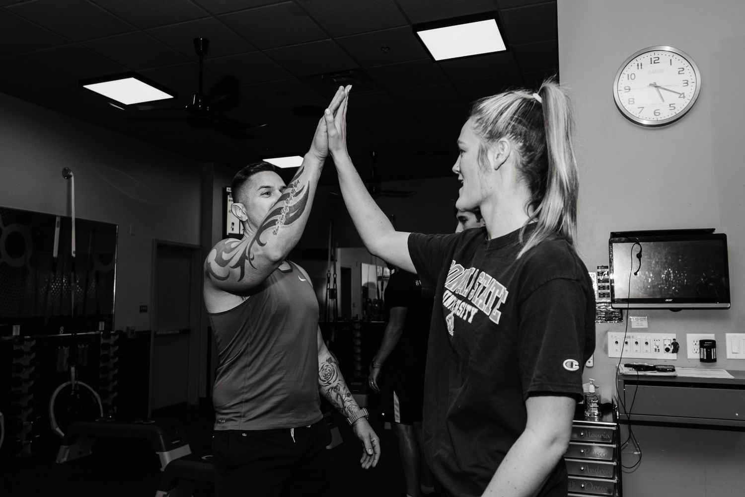 Three dancers in a dimly lit studio practice a modern dance routine in a dynamic choreographed sequence.