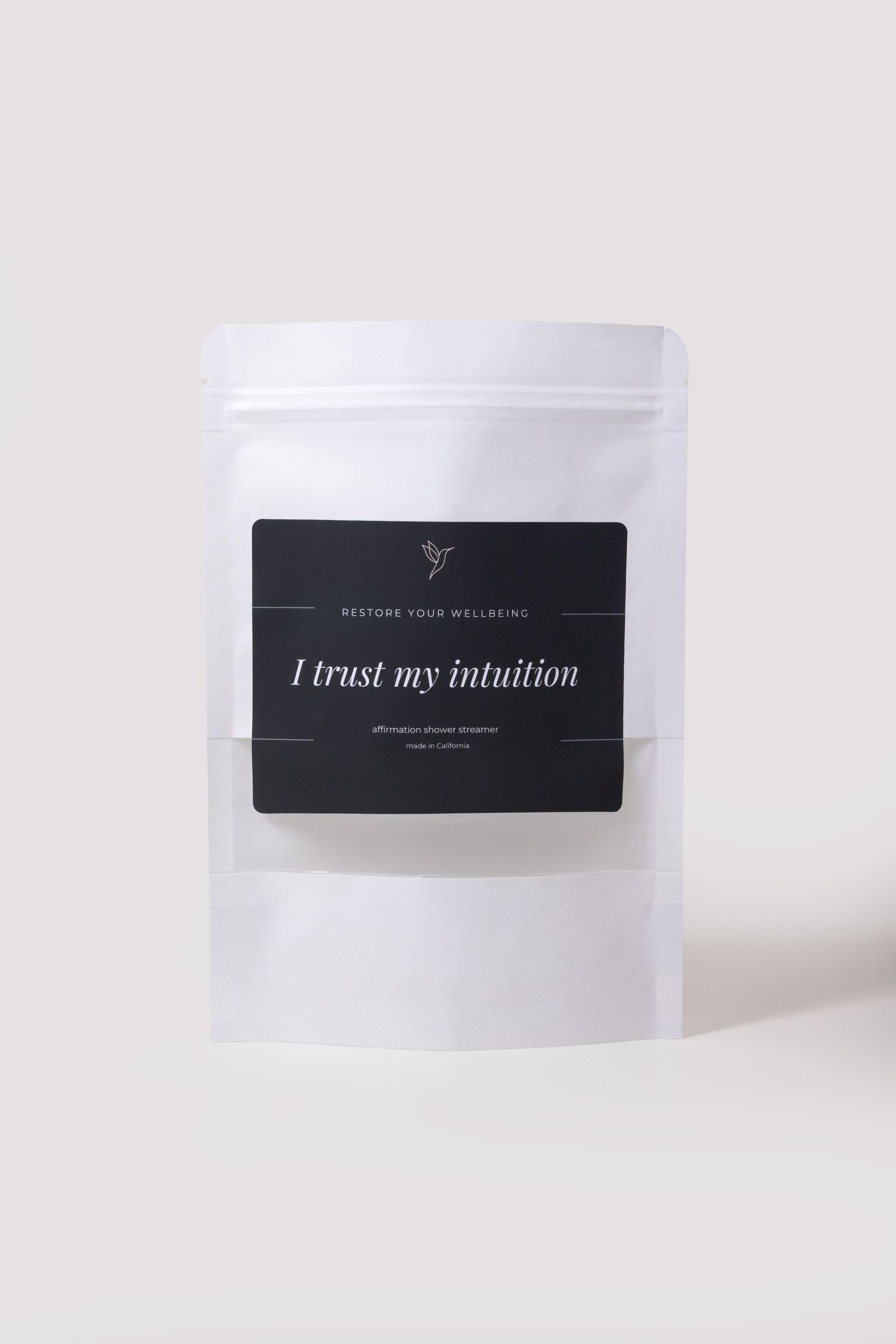 White pouch with black label reading 'I trust my intuition' from Restore Your Wellbeing affirmation tea blend.