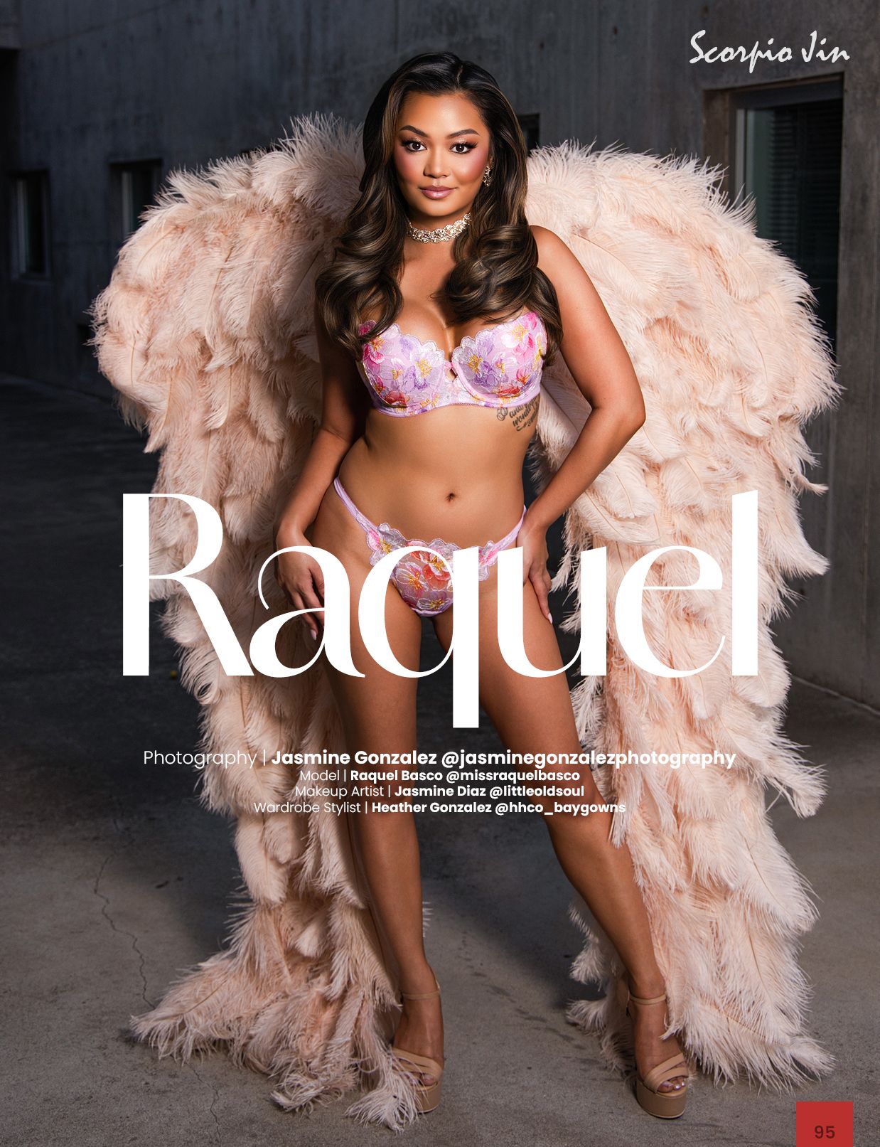 Model Raquel poses in floral lingerie with large feathered wings in a professional fashion shoot.