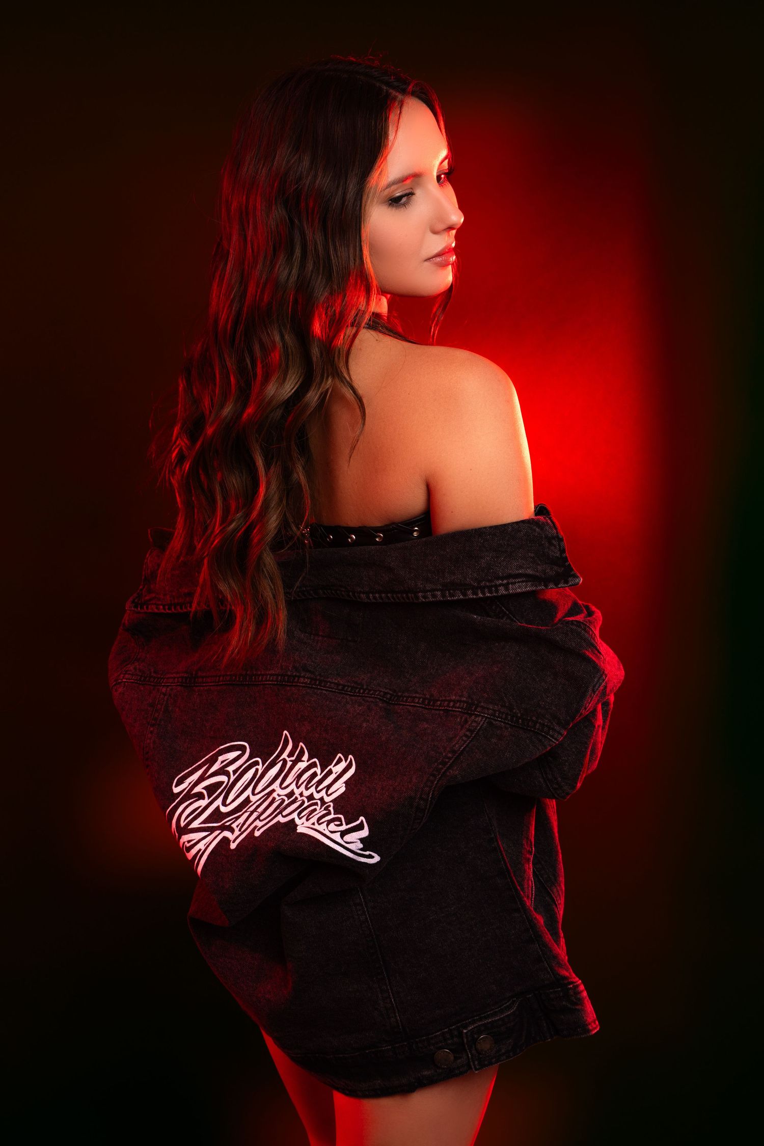 Artistic portrait series with dramatic red lighting showing a figure in black clothing against dark background.