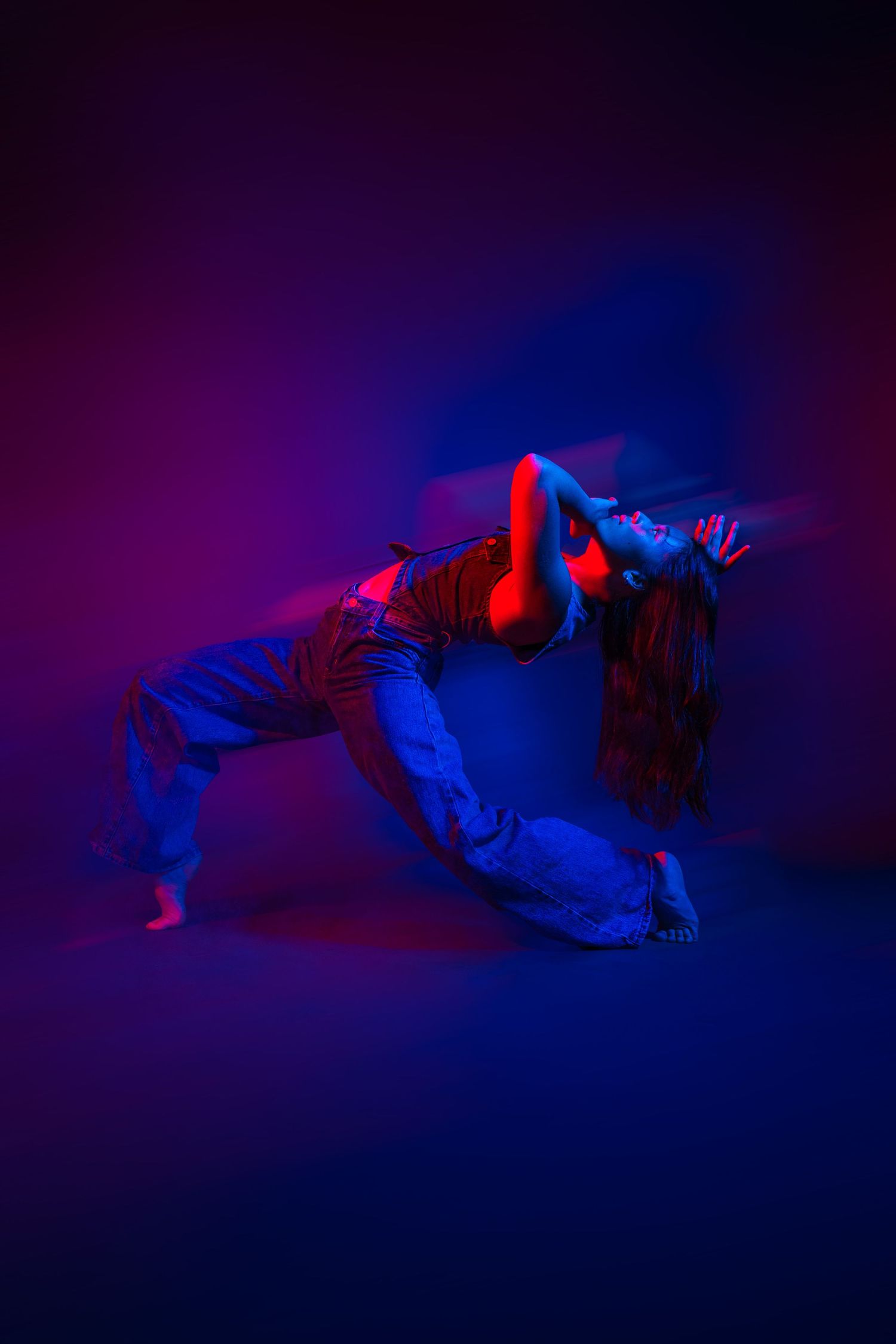Dancer performs dramatic poses in purple and blue lighting creating an ethereal sequence.