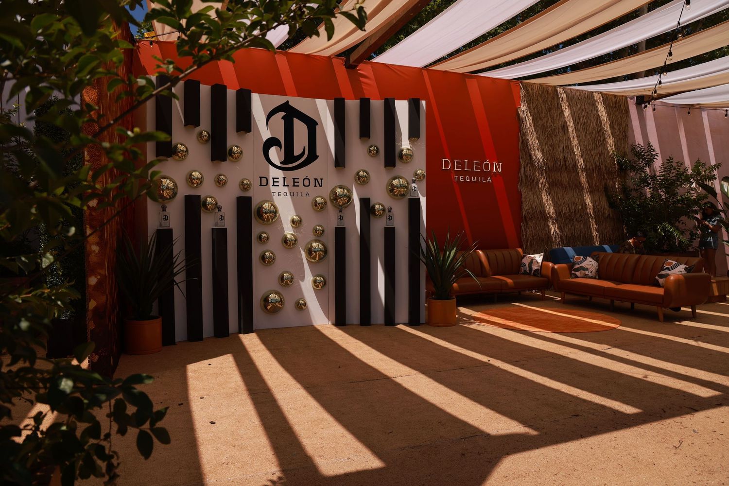 Sunlight streams through striped awnings creating dramatic shadow patterns on a restaurant patio floor.