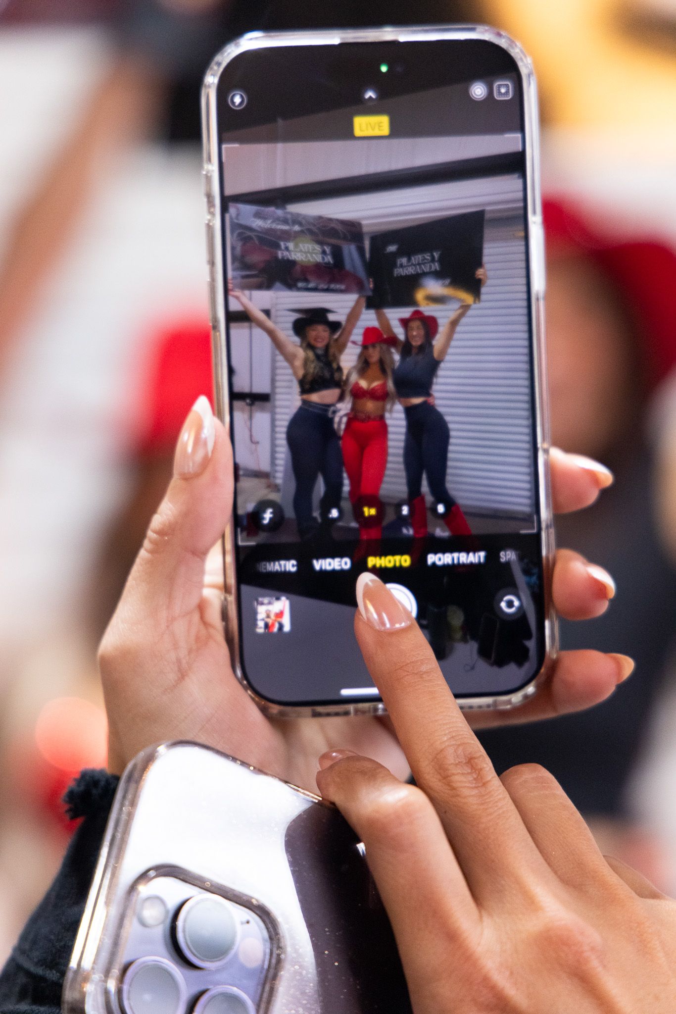 Hands holding smartphones to capture video of a performance or event.