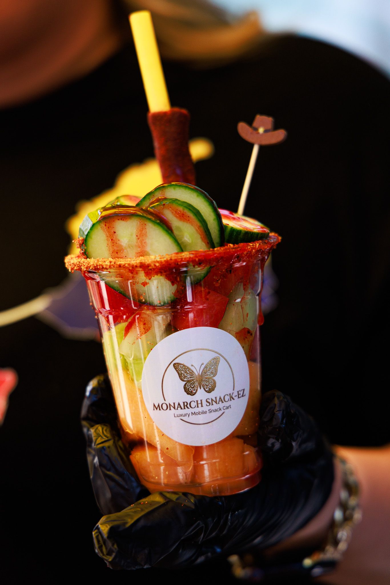 Monarch Snack-Ez branded Mexican snack cup loaded with cucumber, chamoy, and candy straws.