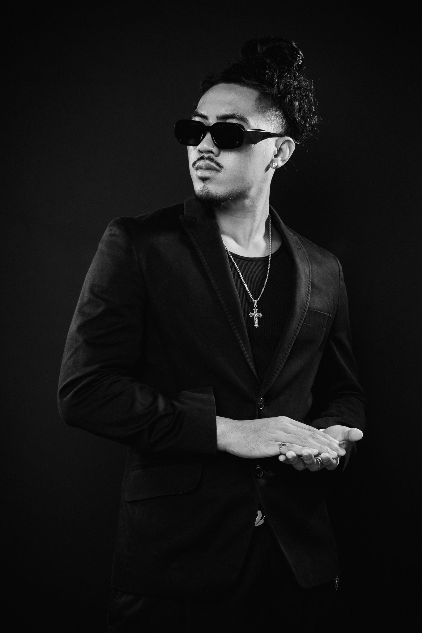 Dramatic black and white portrait series showing a figure in dark clothing and sunglasses against a black background.