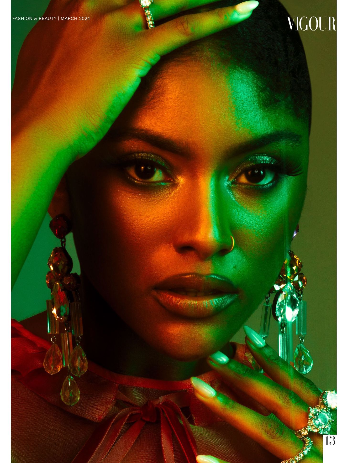 Art portrait with dramatic green and orange lighting highlighting crystal earrings and bold makeup.