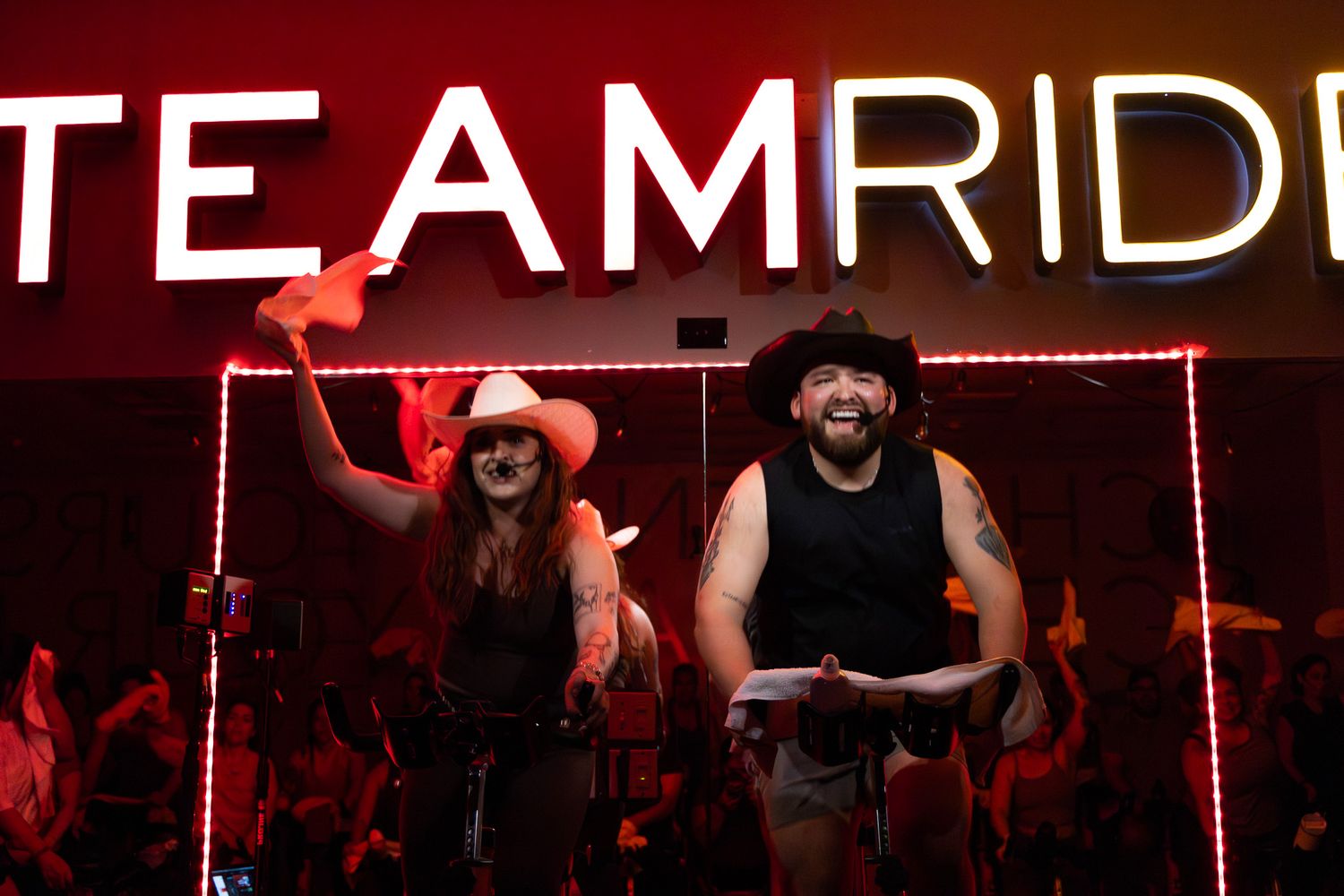 Concert venue with red lighting and crowd silhouettes during a live performance.