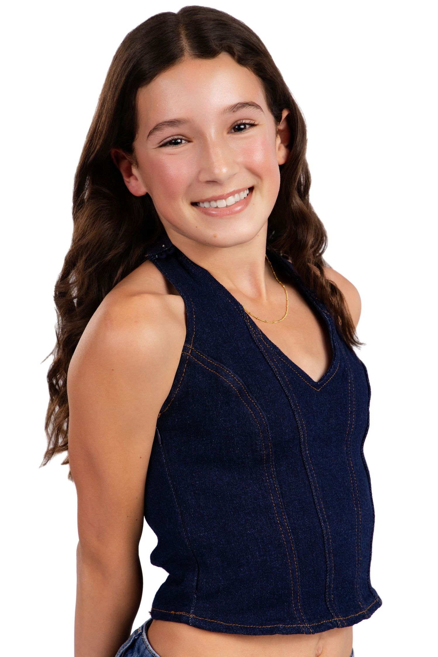 Model in dark denim sleeveless top poses confidently against white studio background.