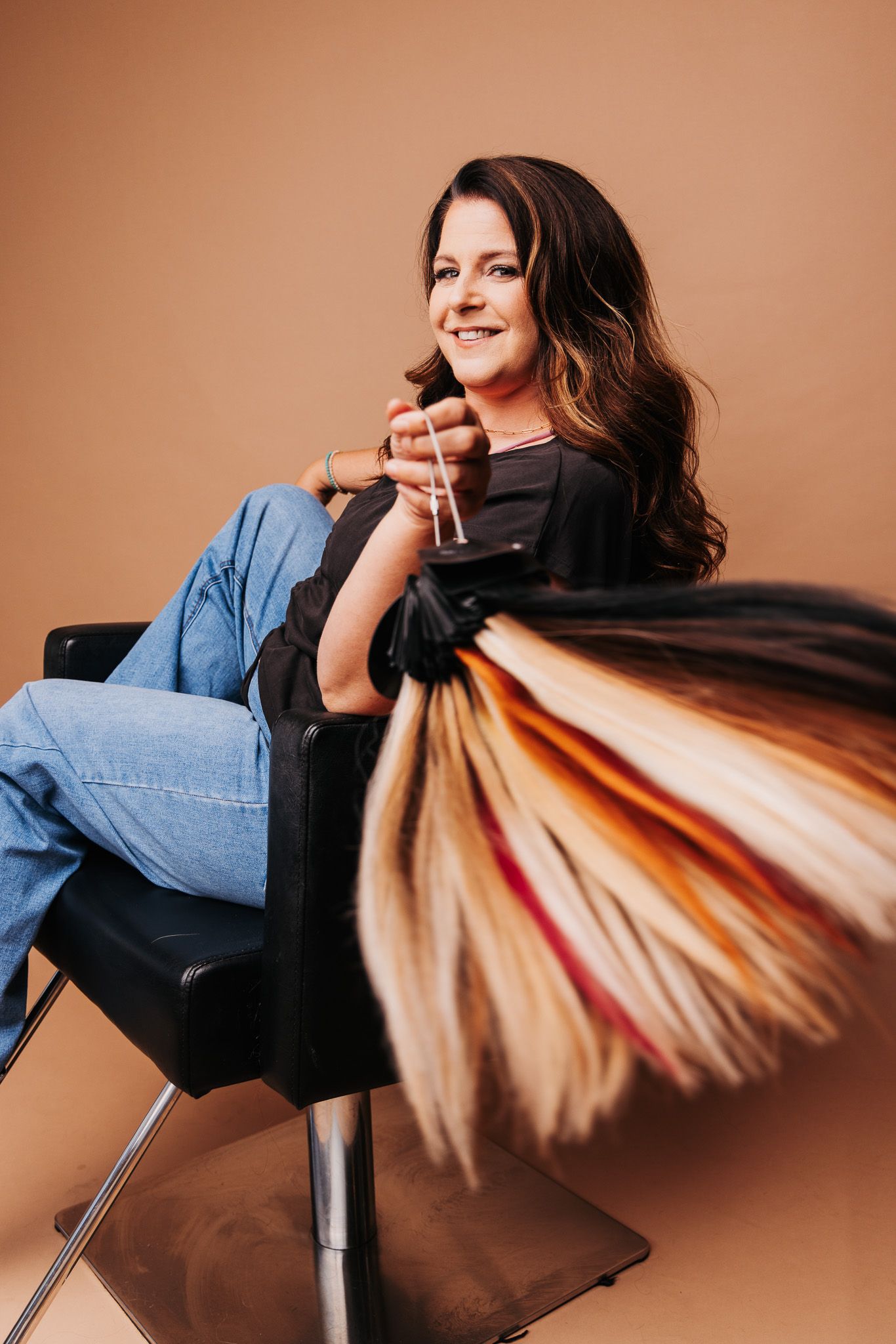Model in black and denim creates dynamic motion shots while seated on brown background.
