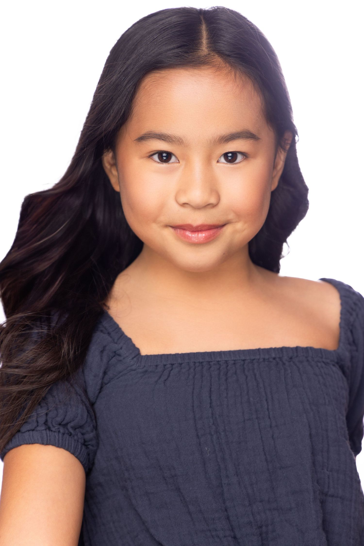 A series of four similar portrait headshots showing a smiling person wearing a navy blue off-shoulder top.