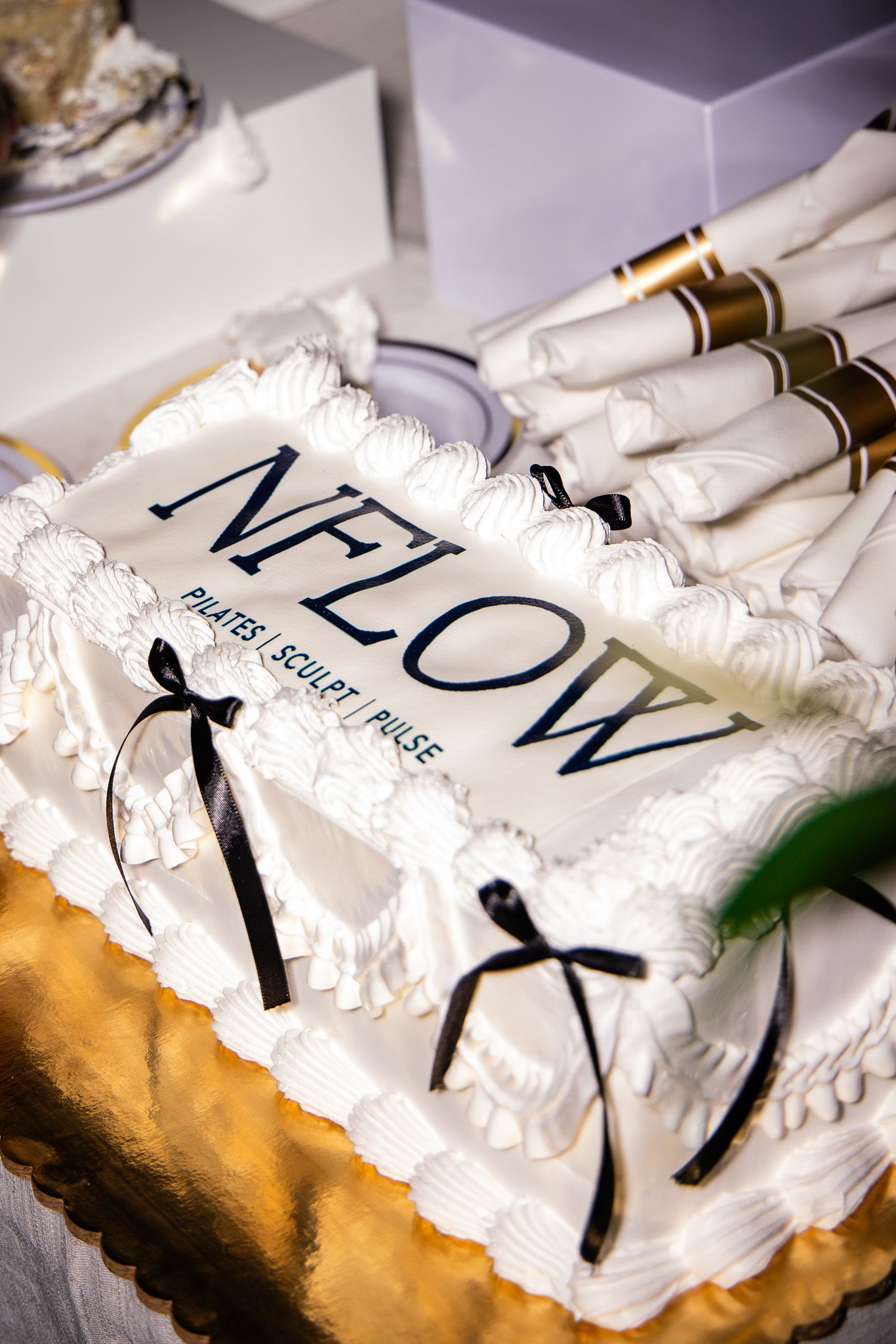 A series of white frosted cakes or pastries with decorative text arranged in a row on a light surface.