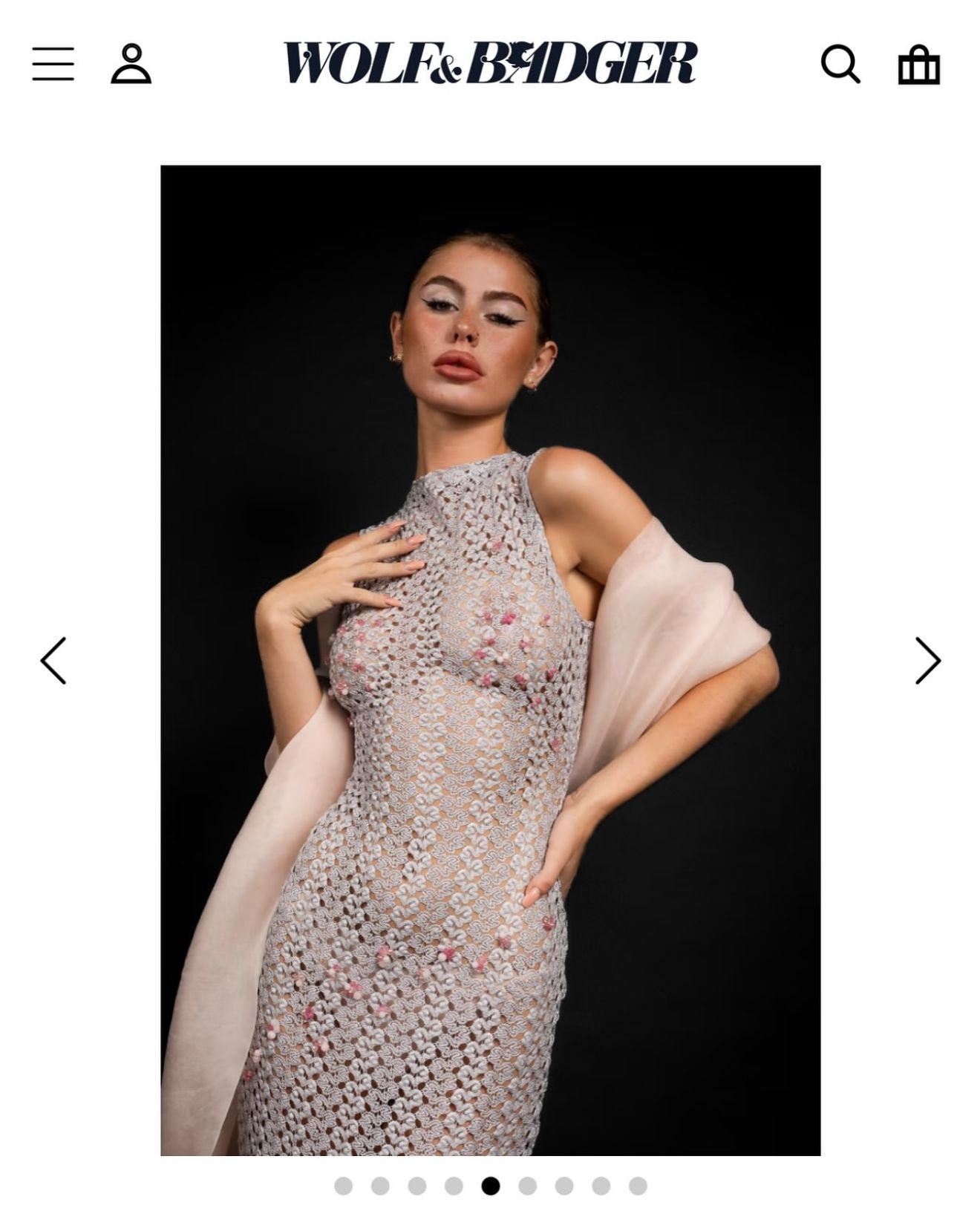 Model wearing a sheer beaded halter midi dress with floral embellishments on Wolf & Badger fashion platform.