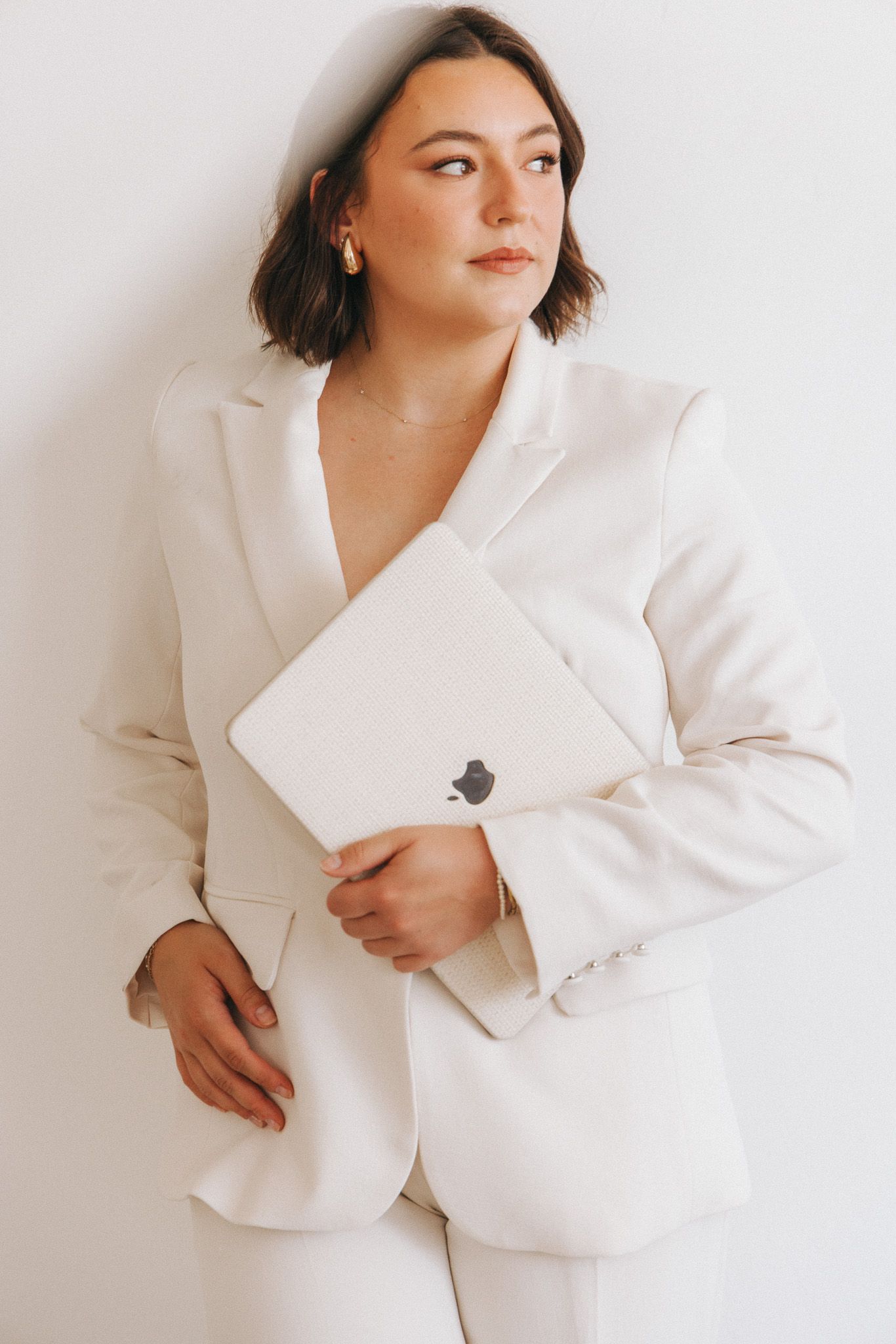 A series of elegant fashion portraits featuring someone in a crisp white blazer against a minimal white background.