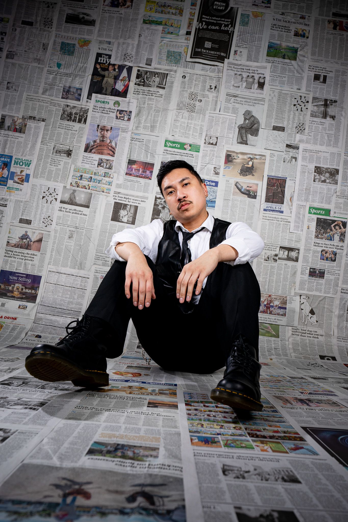 A series of artistic photos showing a figure in business attire posing against a wall covered in newspaper pages.