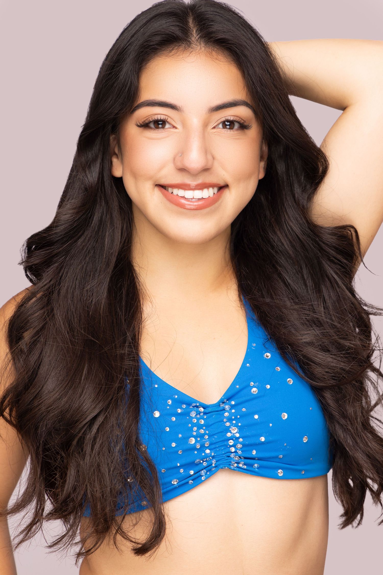 Portrait set showing a sparkling blue top against a soft gray background.