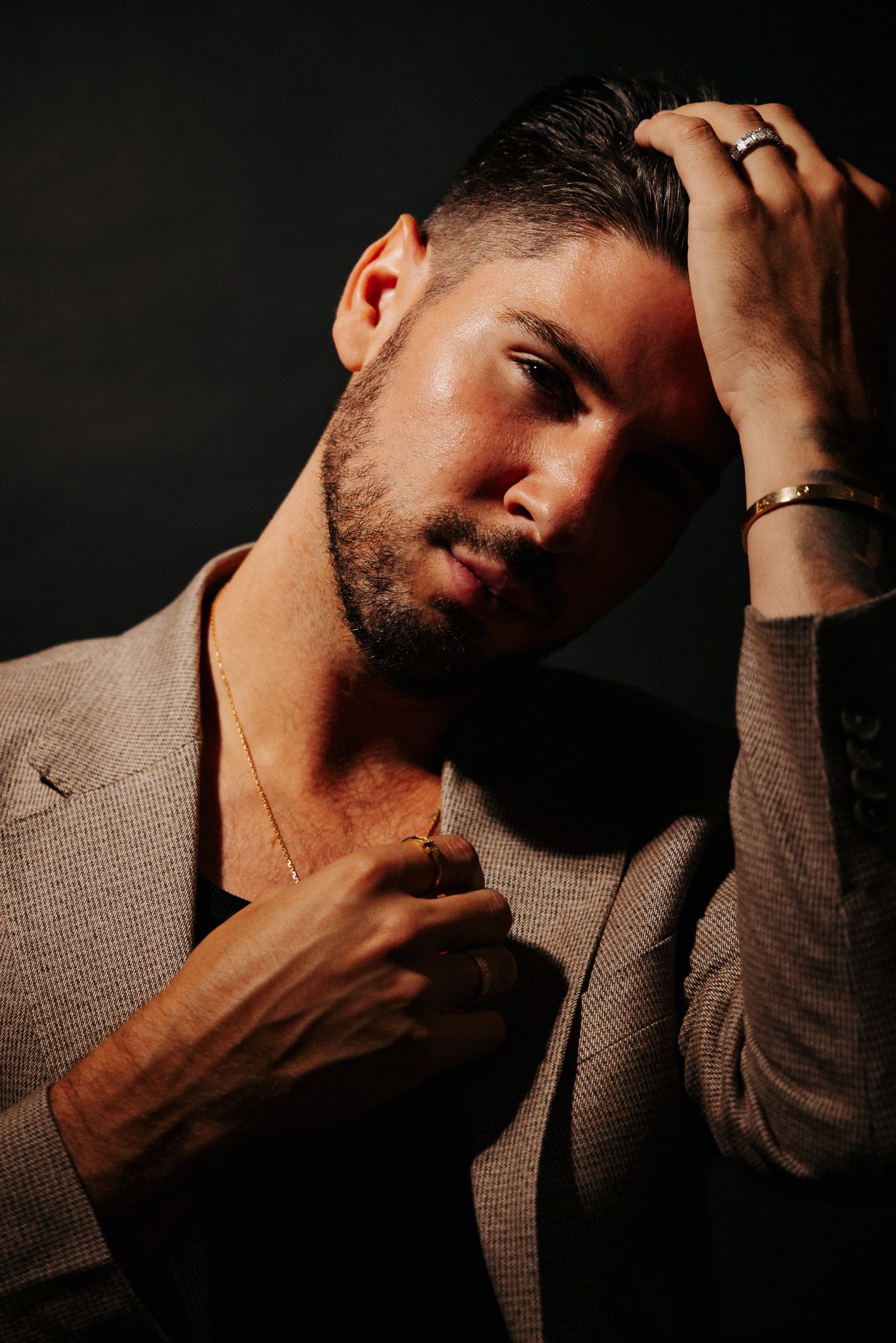 Artistic portrait series showing close-up moody shots of a person in a brown sweater against dark background.