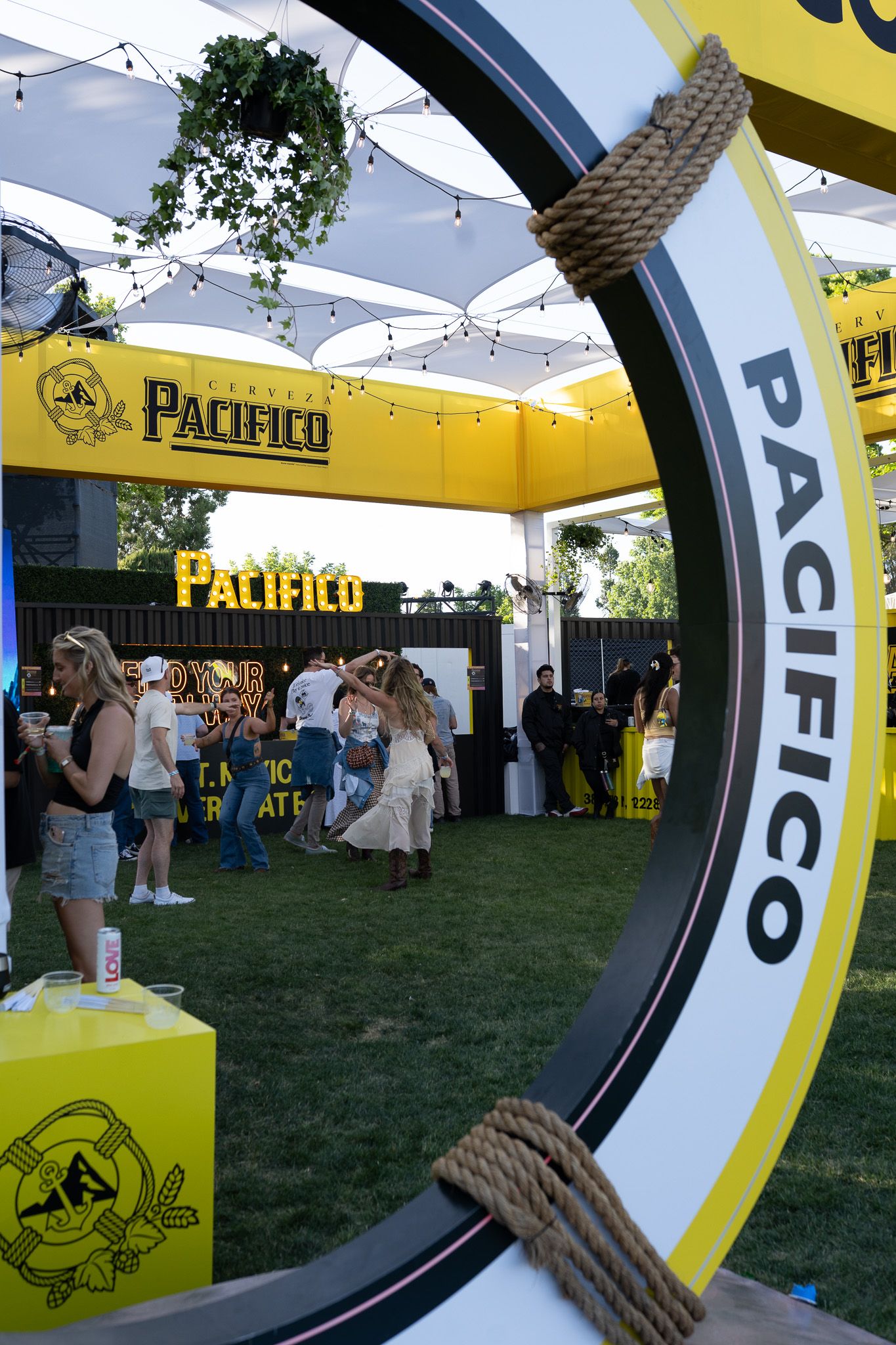 Yellow and black branded tent displays with circular design elements at an outdoor festival event.