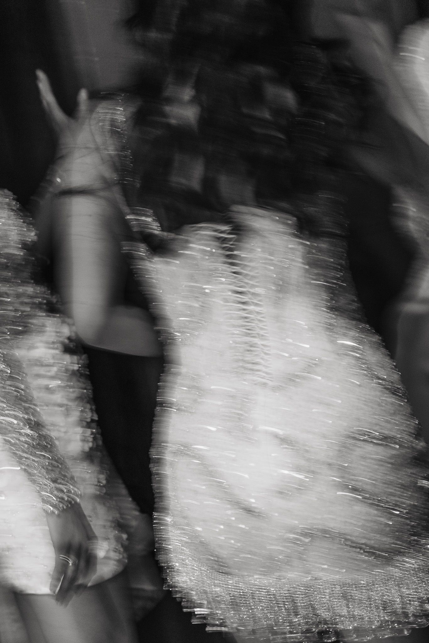 Abstract black and white motion blur creates a ghostly pattern of swirling light and shadow.