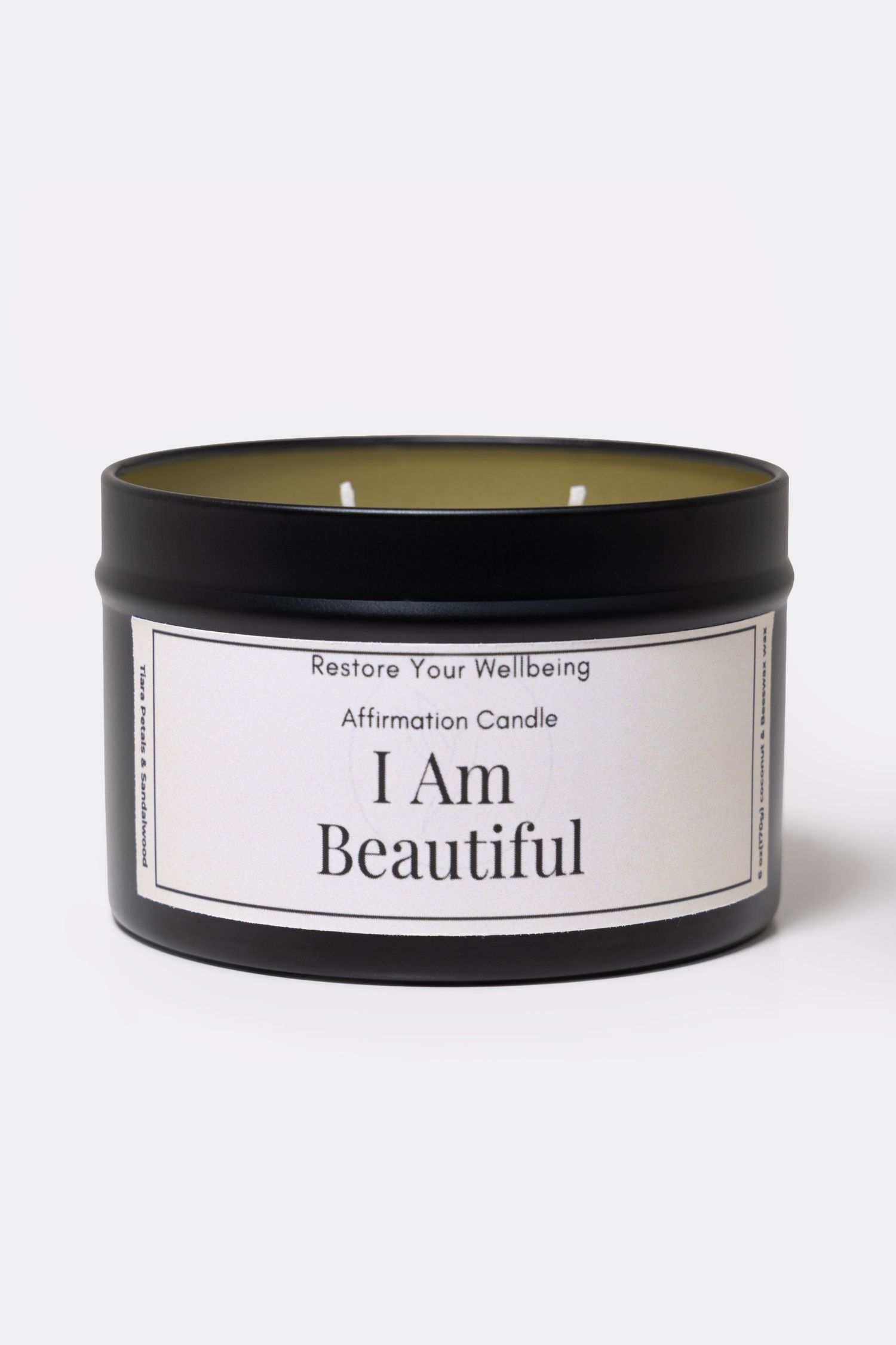 Black tin affirmation candle labeled 'I Am Beautiful' by Restore Your Wellbeing, featuring a white label on matte black container.