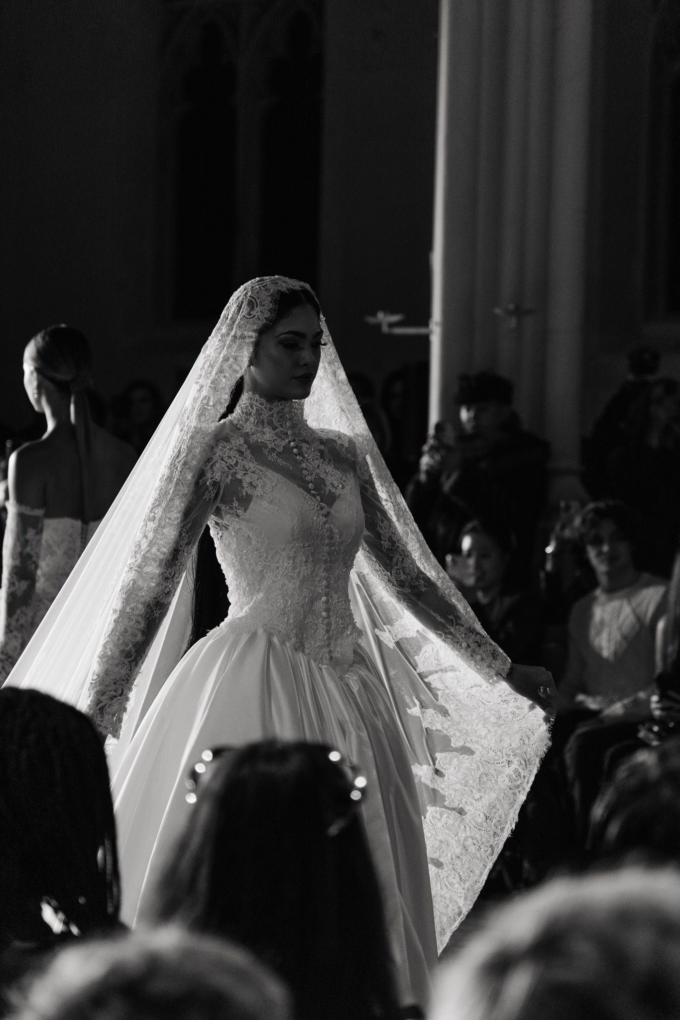 Black and white display of elegant wedding dresses with lace details and flowing silhouettes on mannequins.