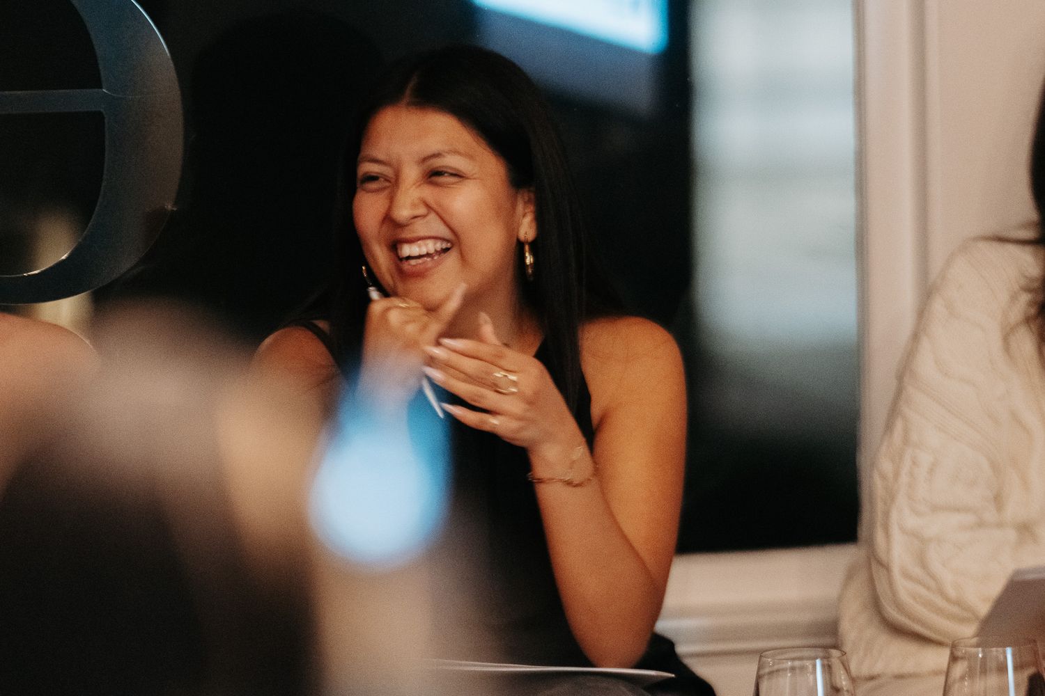 A group shares laughter and conversation during a joyful social gathering.
