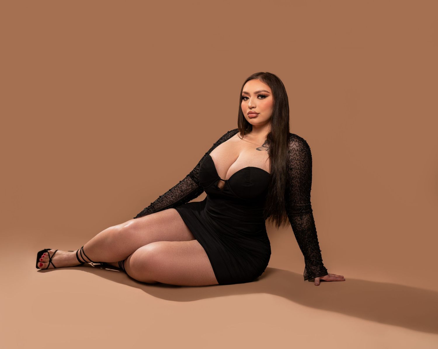 A graceful female figure in a black outfit poses across multiple frames against a warm brown studio backdrop.