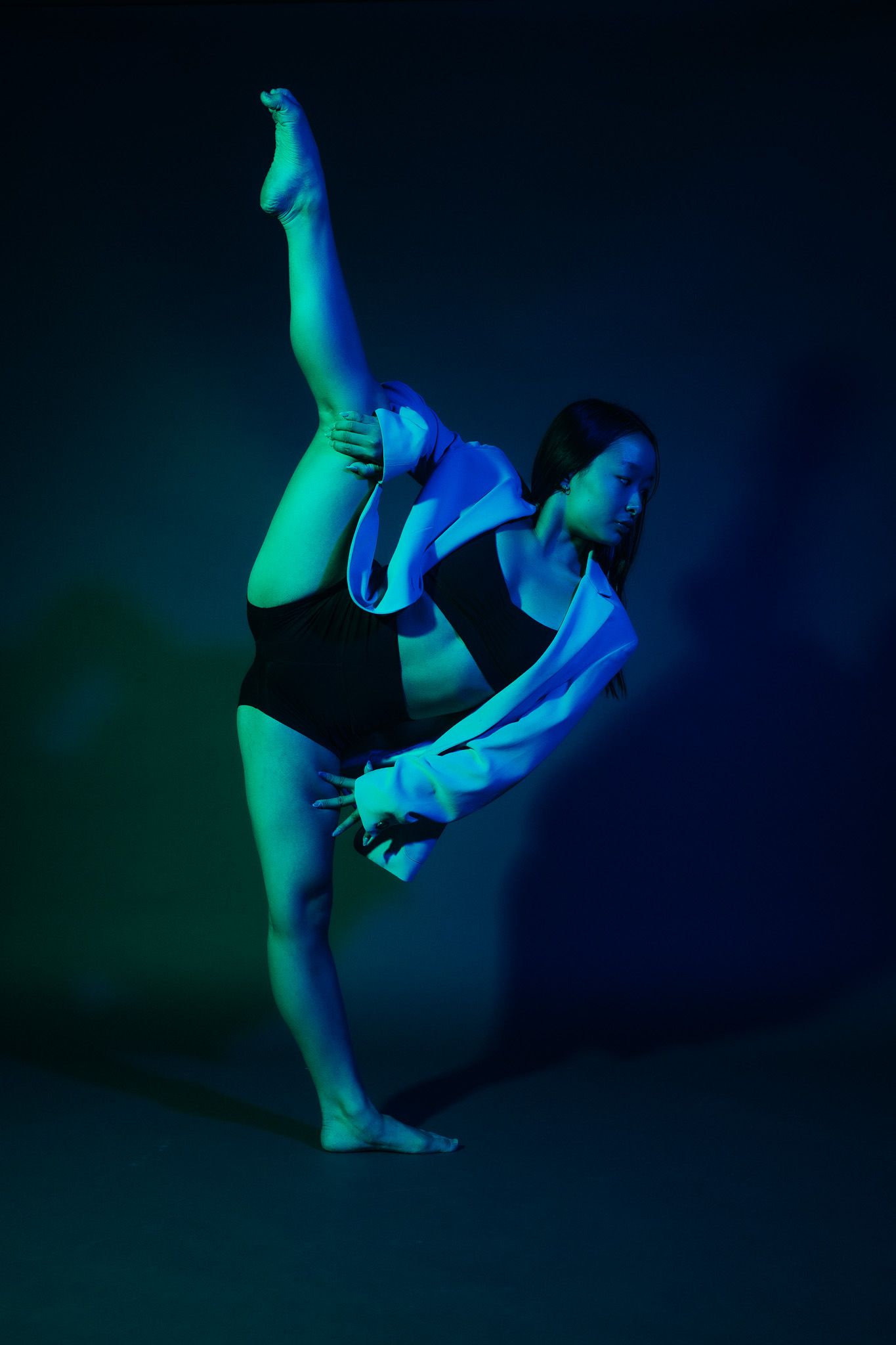 Dynamic silhouettes of modern dance movements captured in blue lighting against dark background in sequence.