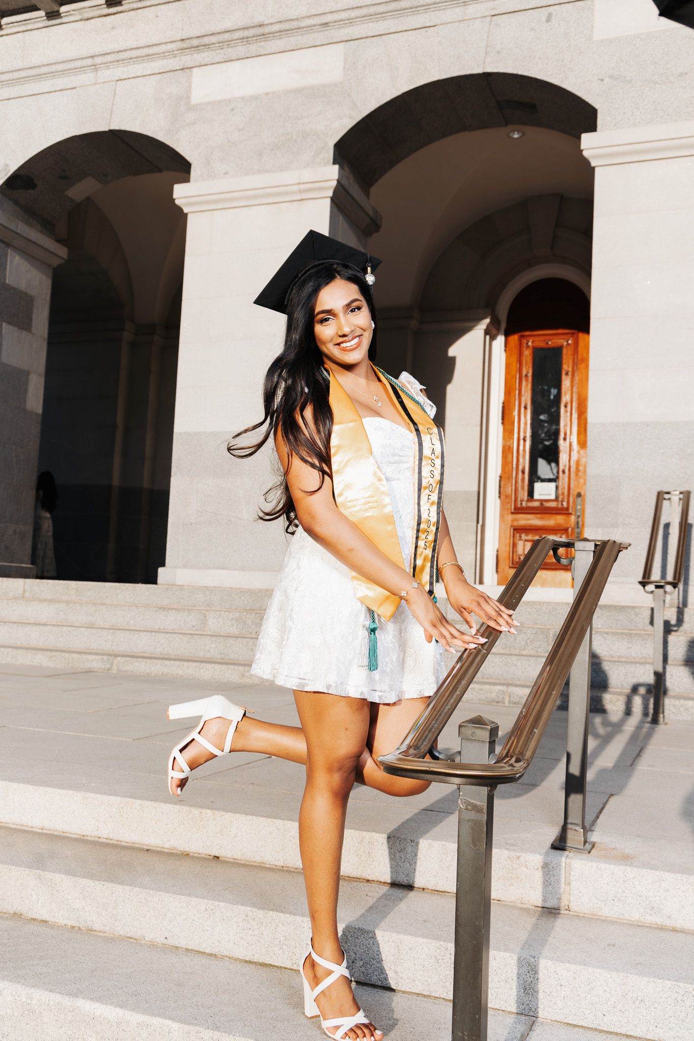 A series of four photos showing someone in a white dress joyfully posing in front of classic stone building arches.