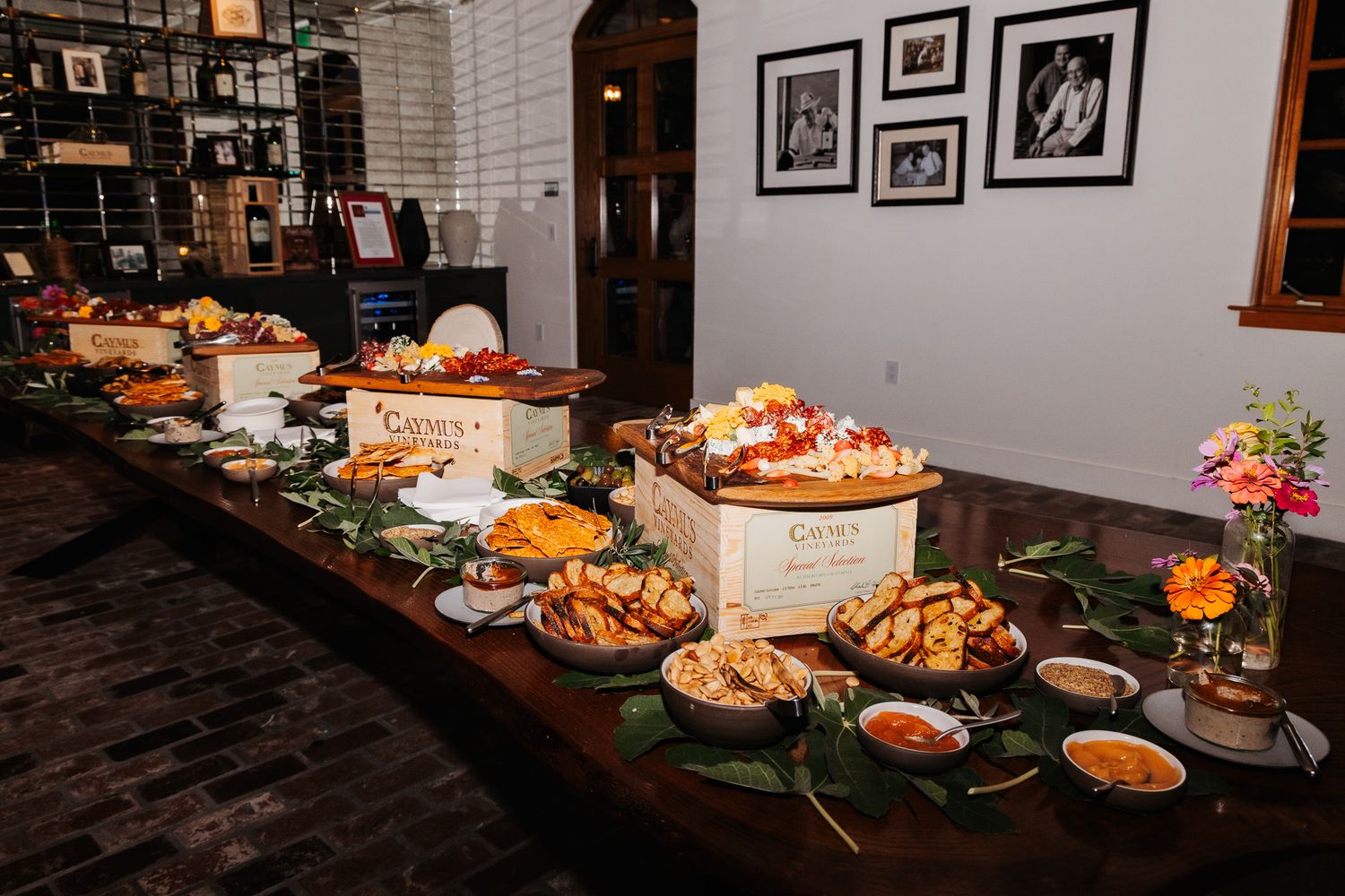 Long buffet table with various appetizers and dishes displayed at an elegant indoor event venue.