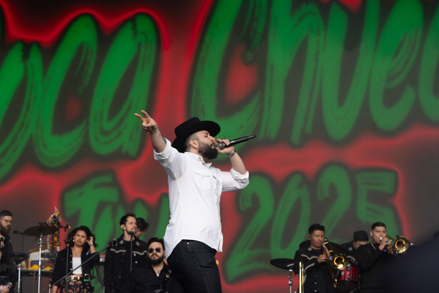 Performer on stage with festive red and green background lighting during holiday concert.