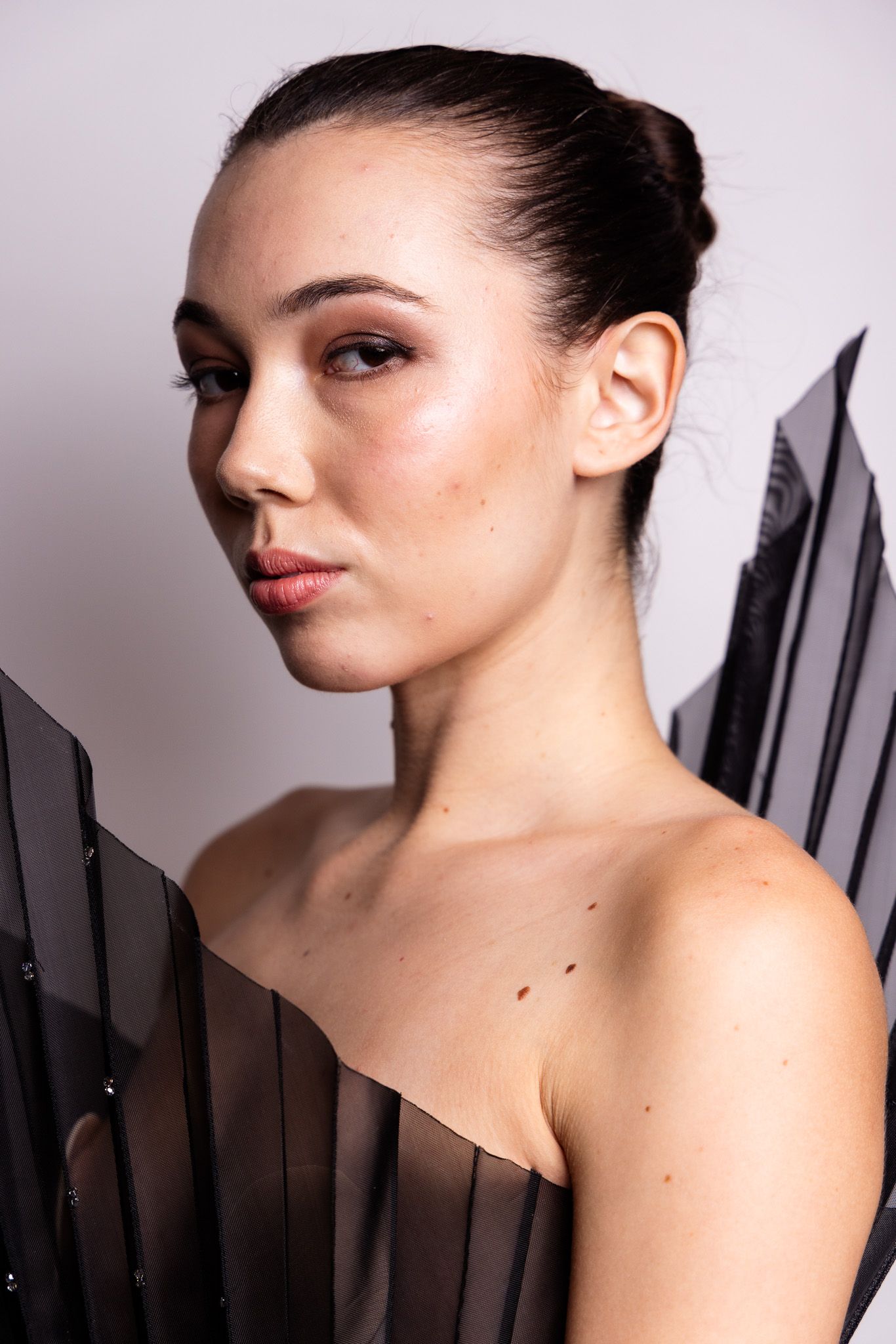 Artistic beauty portrait with dramatic side lighting and sleek hair styling.