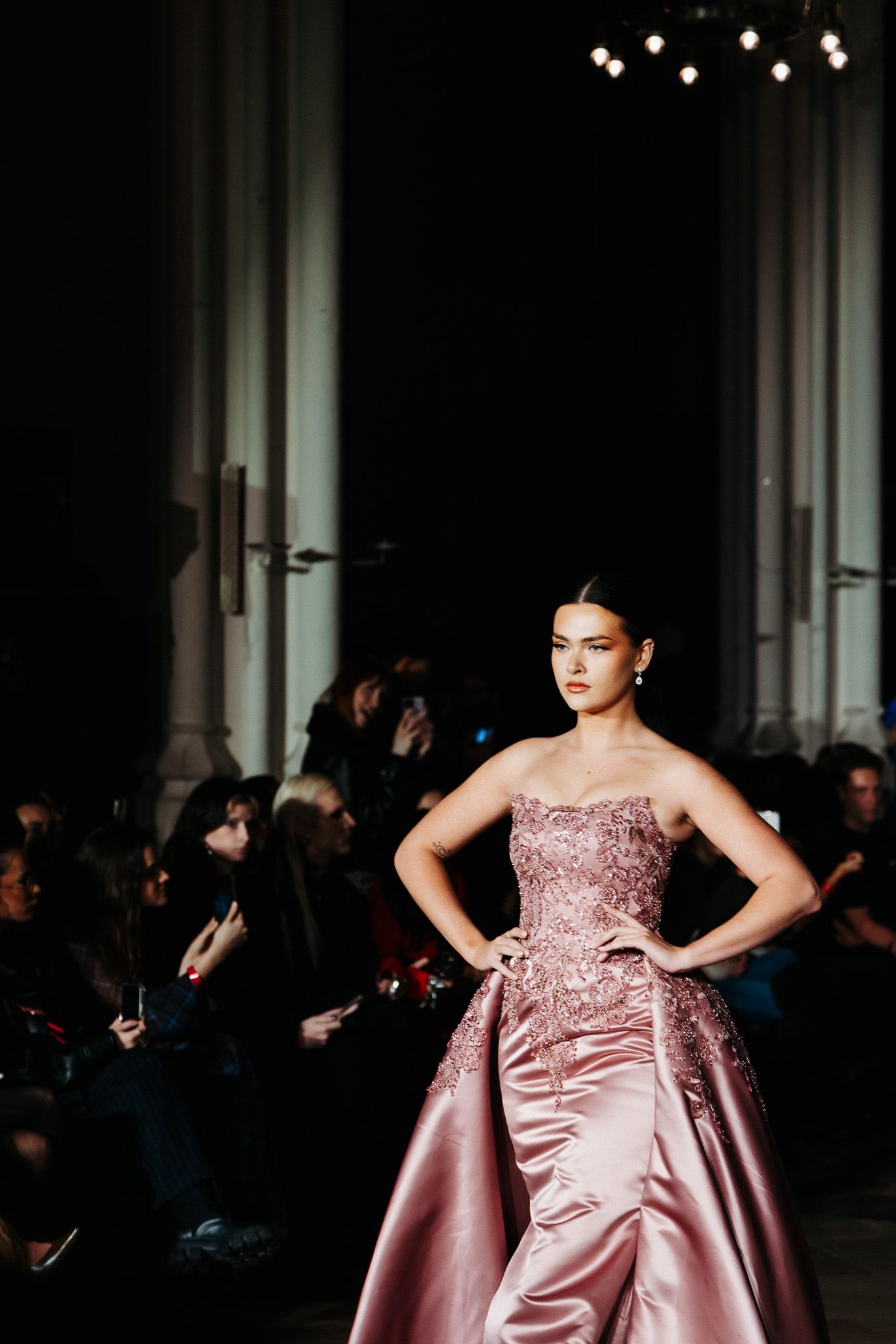 Fashion runway shot of pink satin evening gown with fitted bodice and dramatic train.