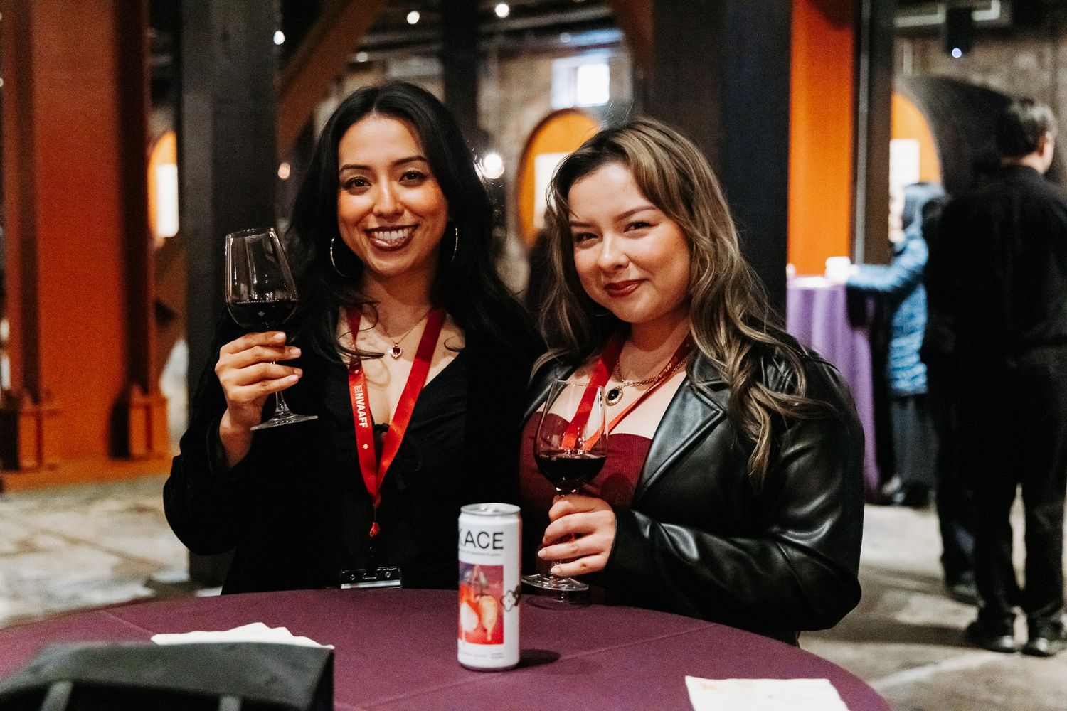 Two attendees enjoying drinks and conversation at an evening social event.