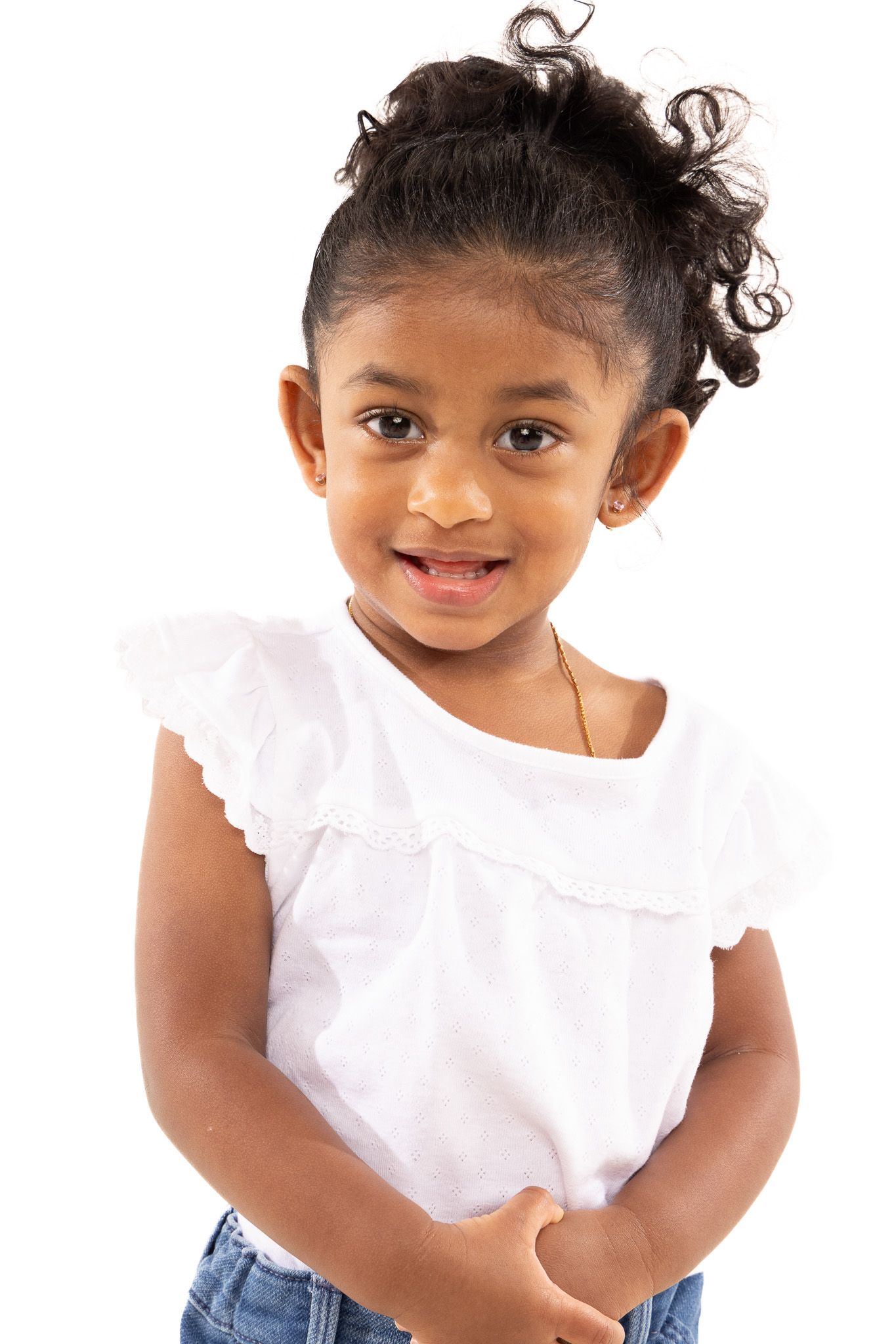 Young child in white ruffled top and jeans poses playfully in a series of connected photos.