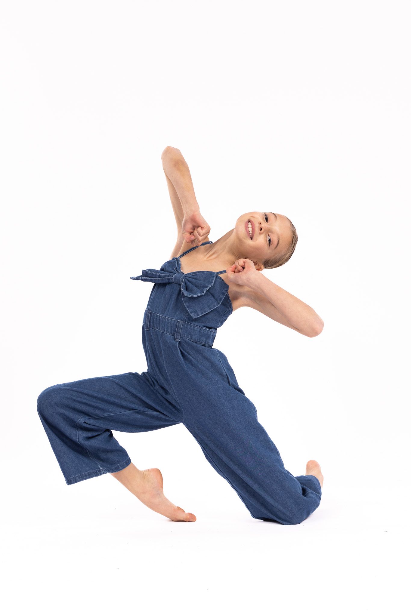 Person in denim dress lying on white background in four different dynamic poses showing movement and flow.
