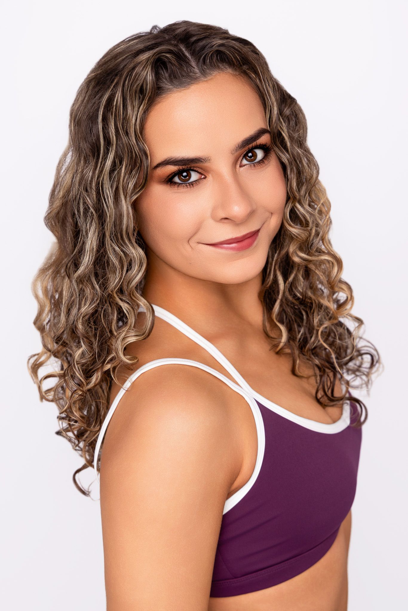A woman with curly brown hair and white top poses in multiple angles against a white background.