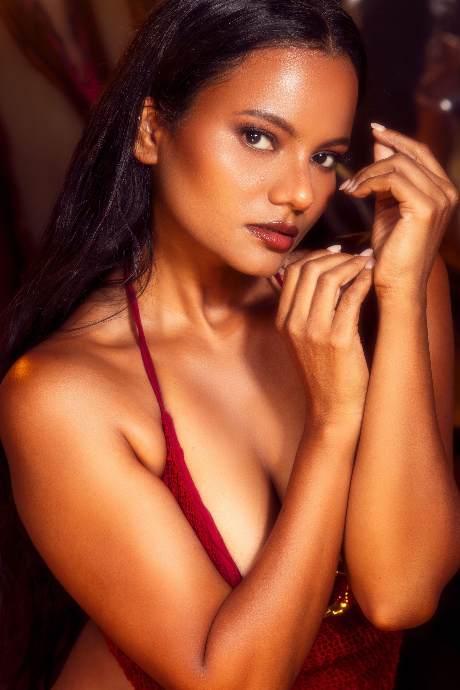 Fashion portrait in deep red lighting showing dramatic shadows and burgundy lingerie details.