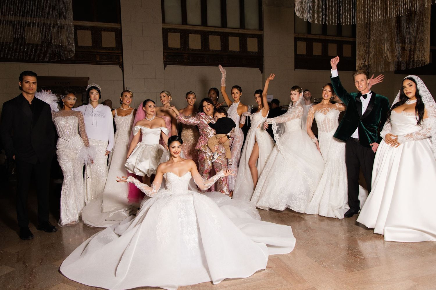 A line of debutantes in white gowns pose elegantly at a formal presentation event.