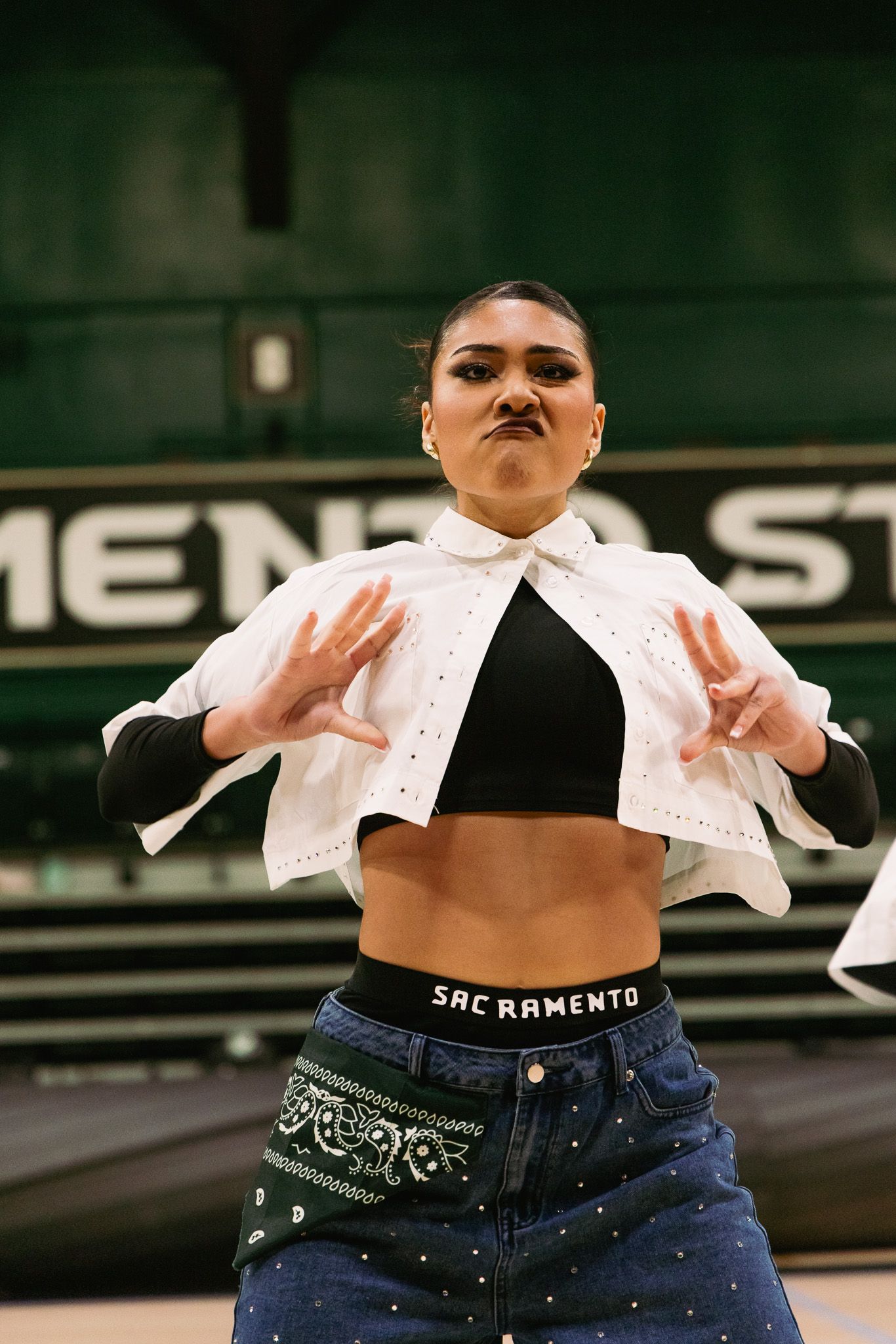 Sacramento State dancer performs in jeans and white top with SAC RAMENTO waistband.