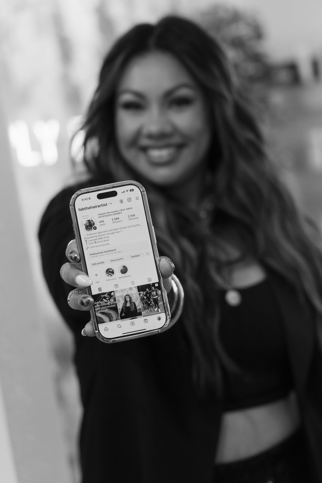 A series of black and white photos showing someone holding up a phone displaying social media content.
