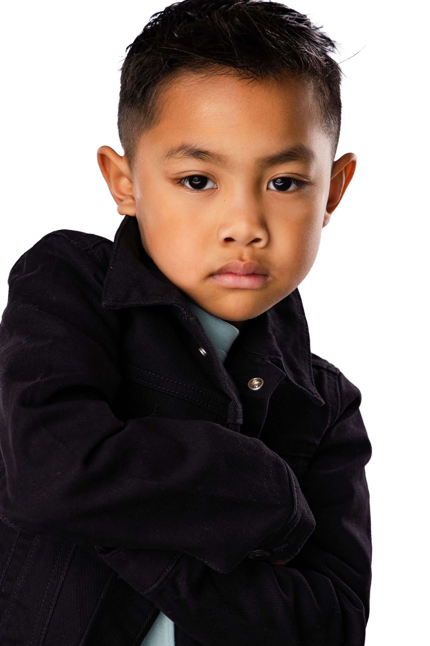 Young child wearing a black hoodie shown in three different poses looking at the camera.