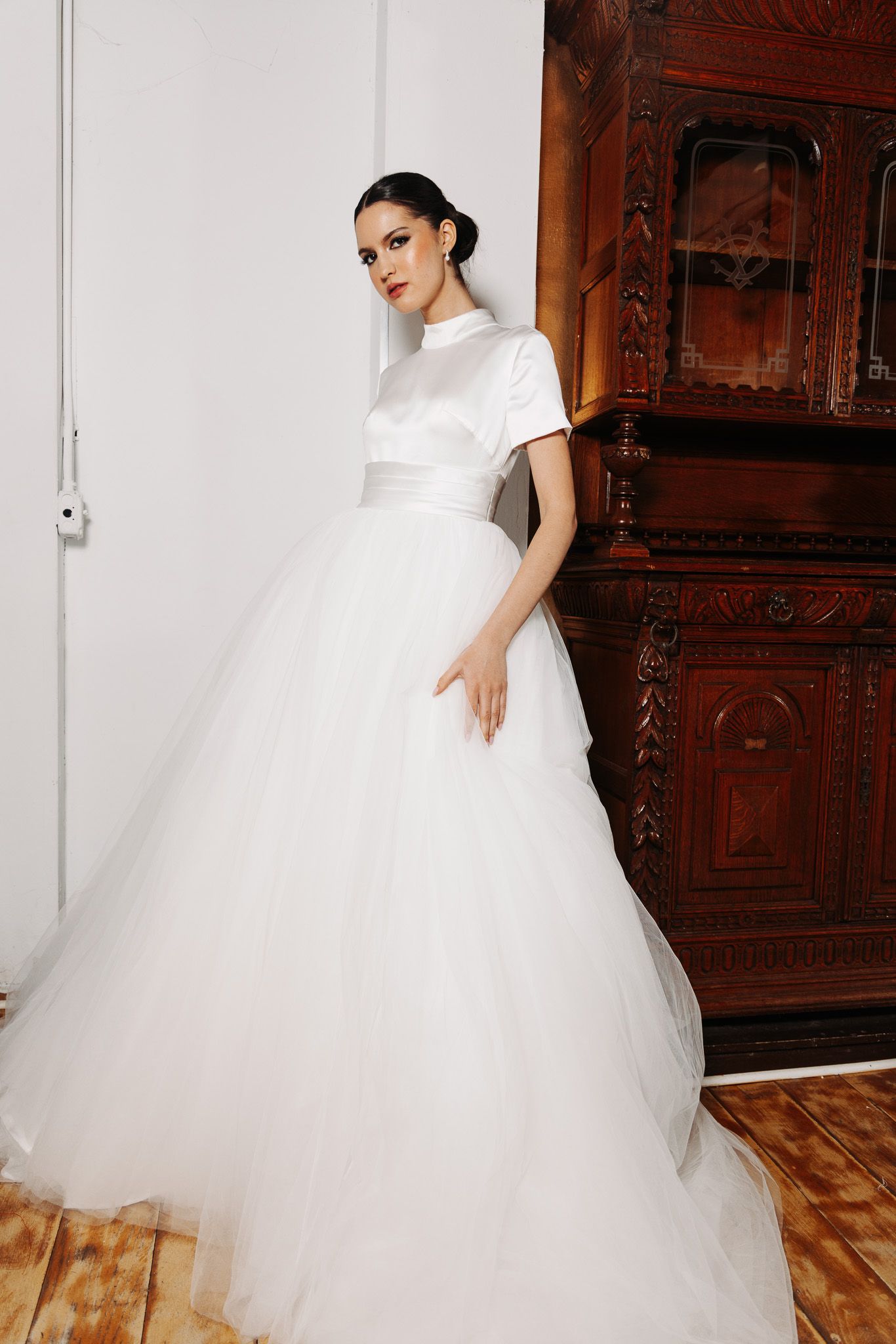 Voluminous white tulle ballgown photographed in sequence against ornate wooden interior.