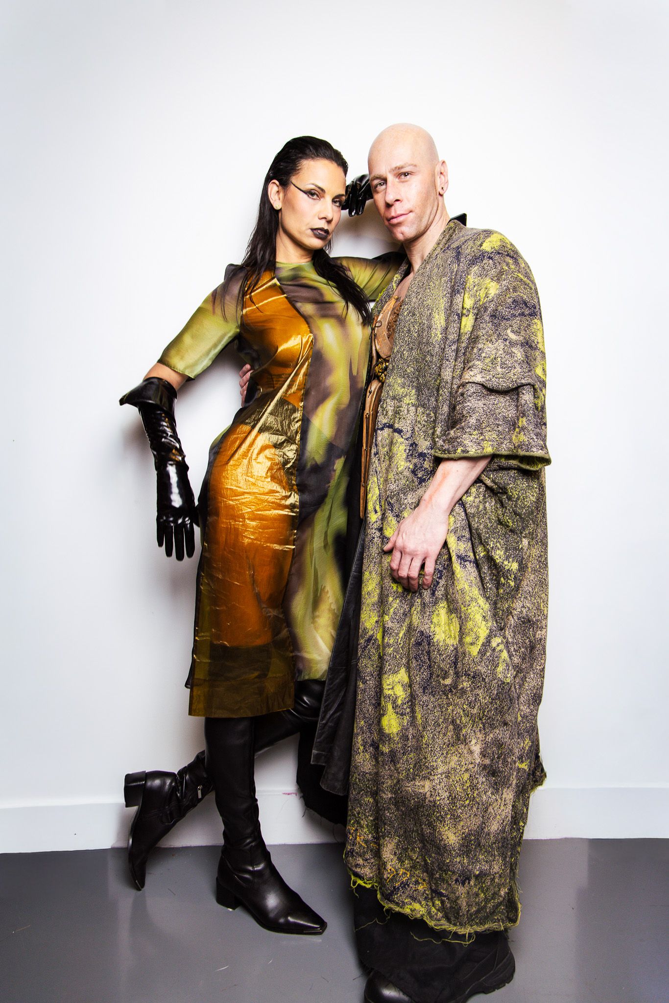 Editorial fashion shoot with metallic gold and camouflage-inspired outfits against white backdrop.