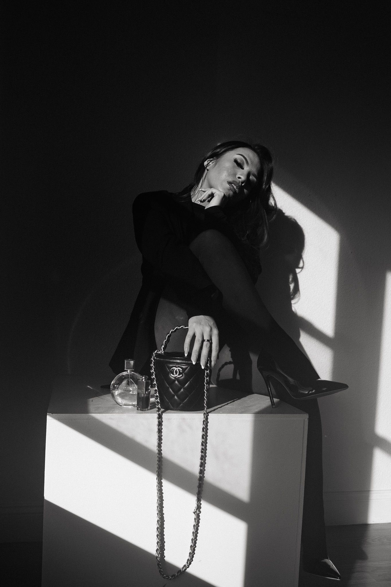 A dramatic black and white series showing a person gracefully posing on a platform with stark lighting and shadows.