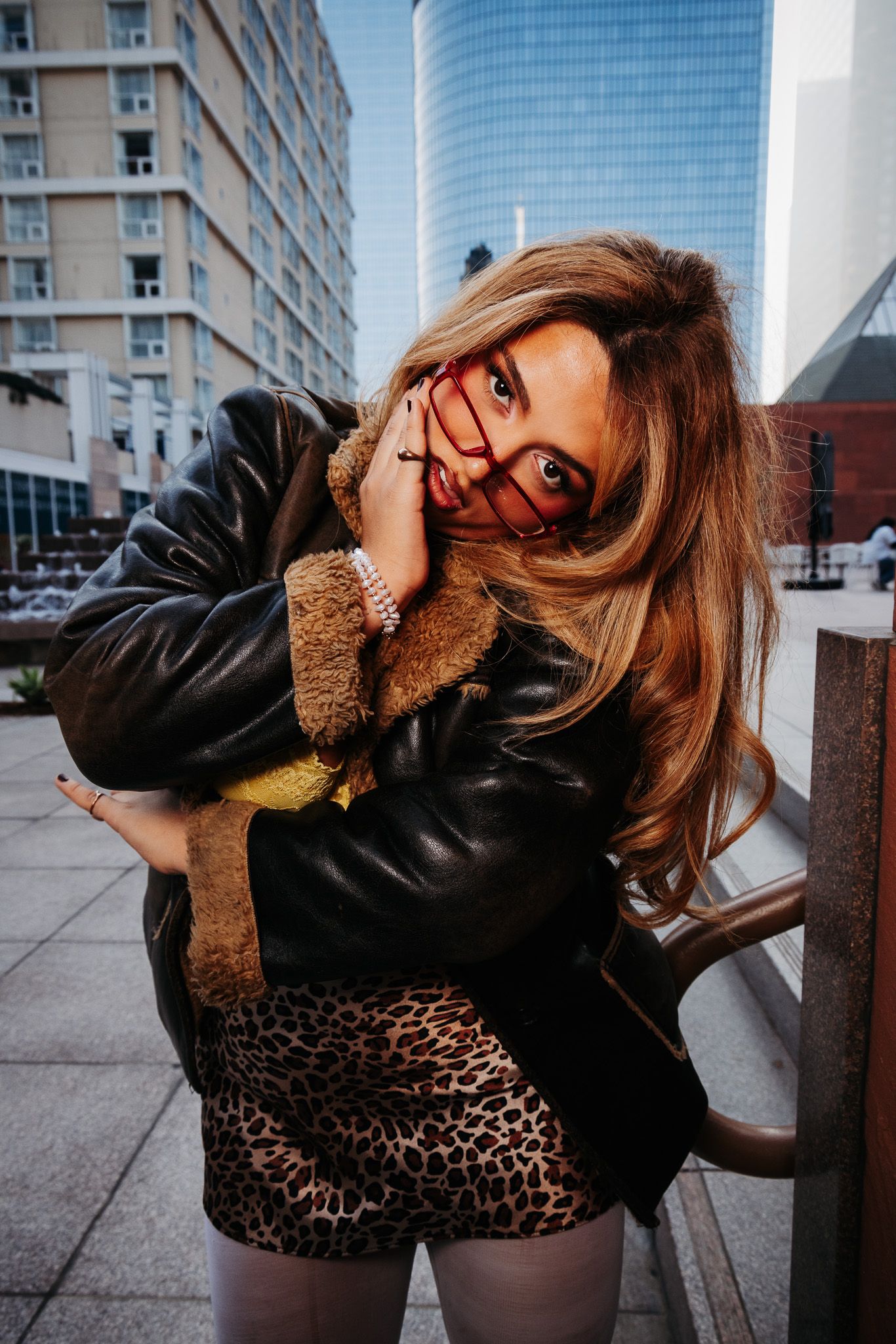 A series of fashion portraits showing poses against an urban backdrop with modern buildings and skyscrapers.